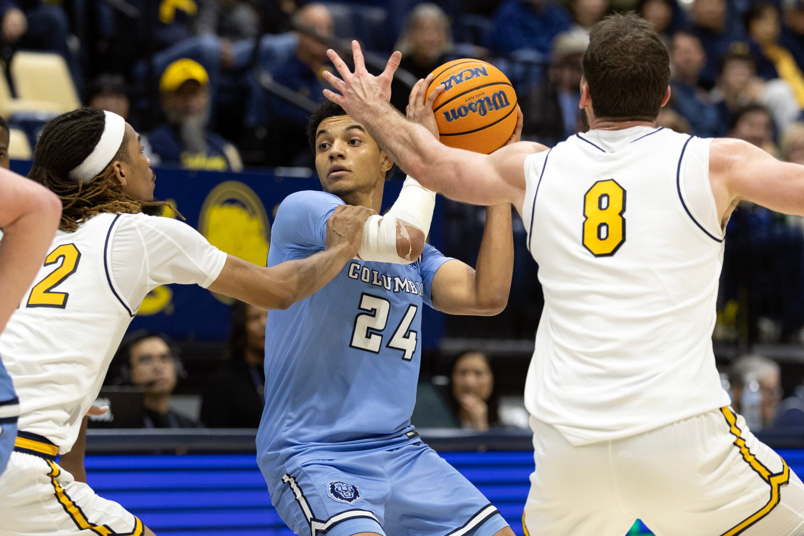 Dec 21, 2025; Berkeley, California, USA; Columbia Lions guard Miles Franklin (24) looks to pass between California Golden Bears defenders Chris Bell (22) and Milos Ili? (8) during the second half at Haas Pavilion. Mandatory Credit: D. Ross Cameron-Imagn Images