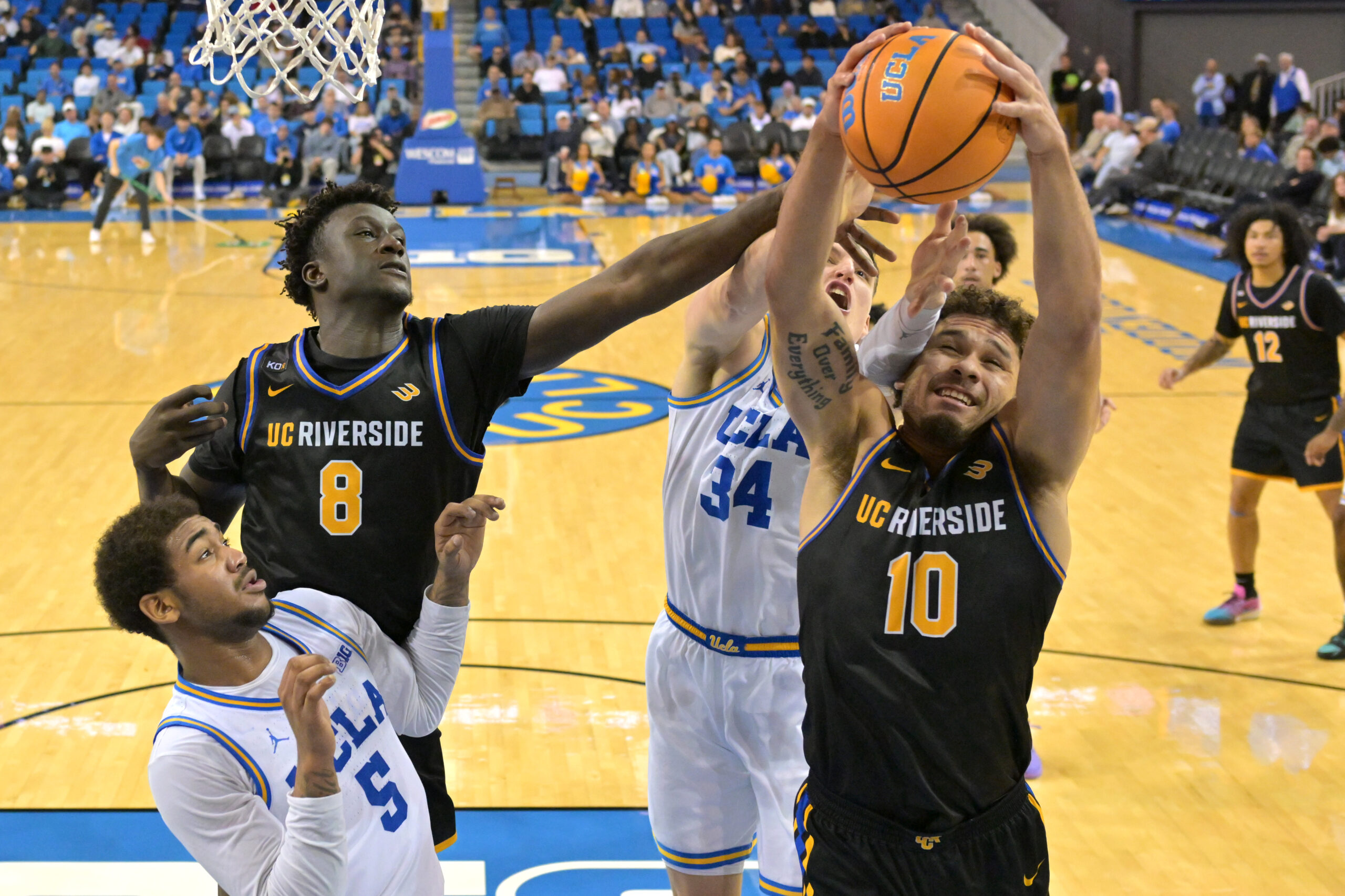 Dec 23, 2025; Los Angeles, California, USA; UCLA Bruins guard Brandon Williams (5) and forward Tyler Bilodeau (34) and UC Riverside Highlanders forward BJ Kolly (8) and UC Riverside Highlanders guard Marqui Worthy Jr. (10) battle for a rebound in the second half at Pauley Pavilion presented by Wescom Financial. Mandatory Credit: Jayne Kamin-Oncea-Imagn Images