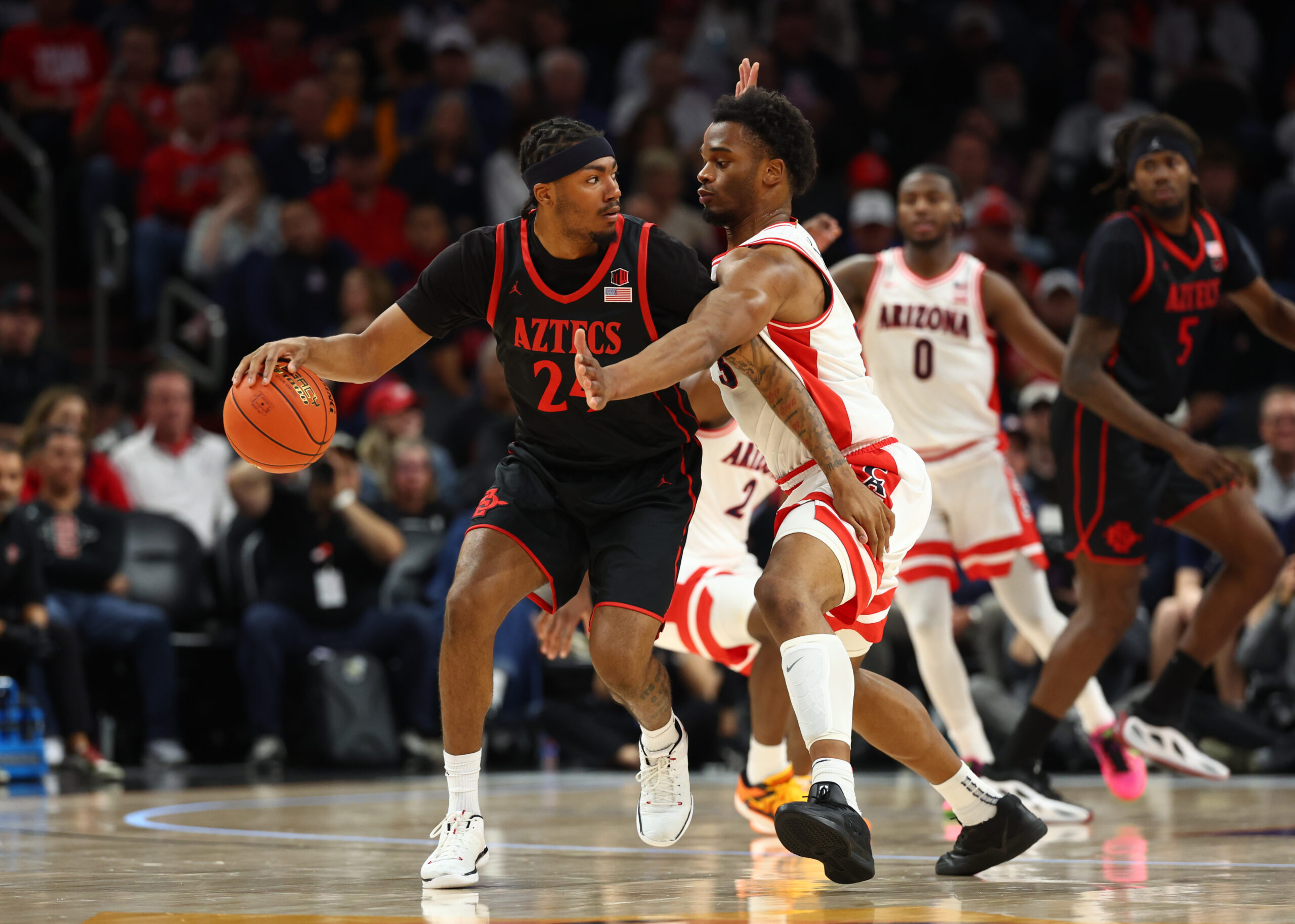 Dec 20, 2025; Phoenix, Arizona, USA; Arizona Wildcats forward Tobe Awaka (30) defends against San Diego State Aztecs guard Taj DeGourville (24) during the Hall of Fame Series at Mortgage Matchup Center. Mandatory Credit: Mark J. Rebilas-Imagn Images