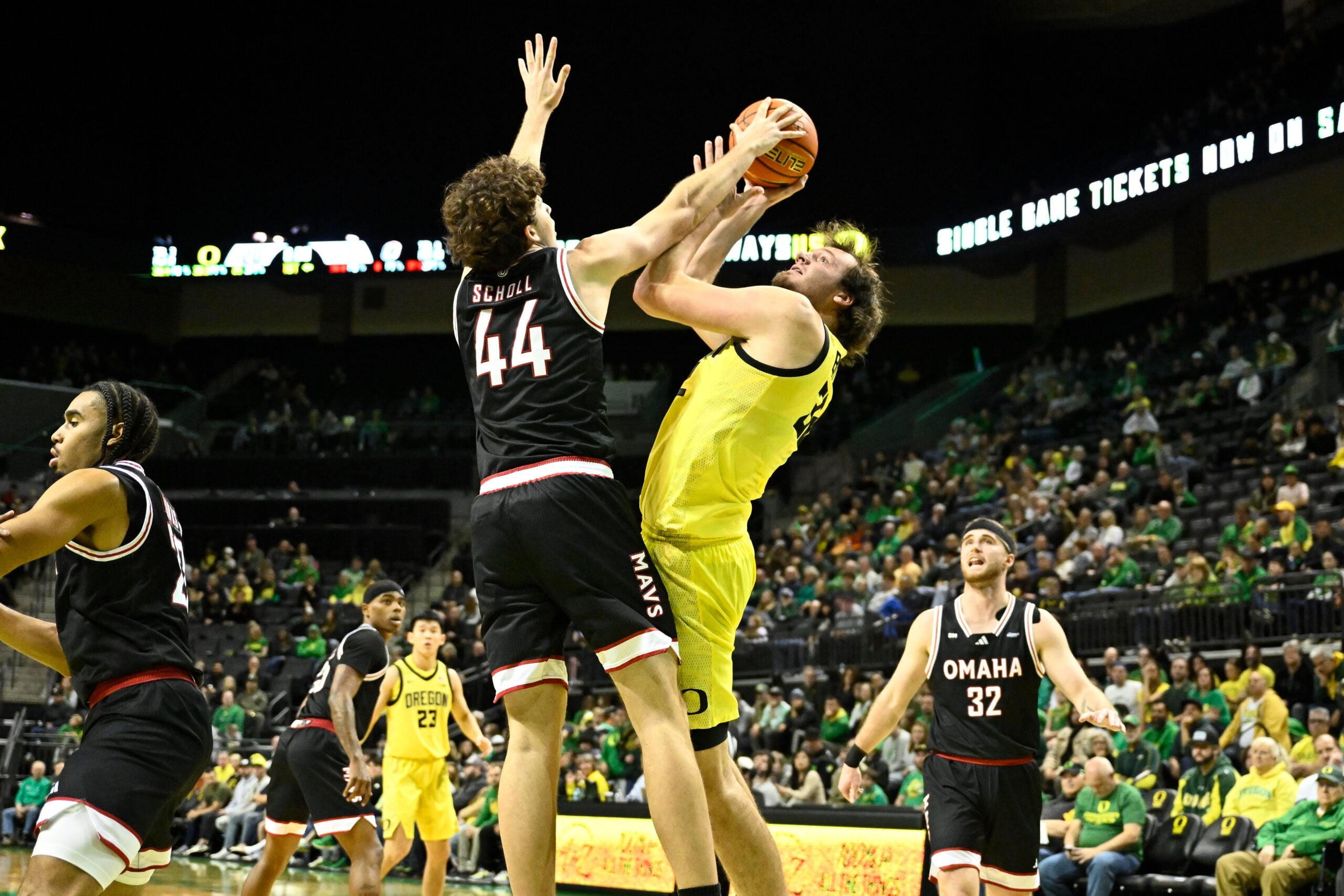 Dec 28, 2025; Eugene, Oregon, USA; Omaha Mavericks forward Brock Scholl (44) blocks a shot by Oregon Ducks center Nate Bittle (32) but is called for a foul during the first half at Matthew Knight Arena. Mandatory Credit: Craig Strobeck-Imagn Images
