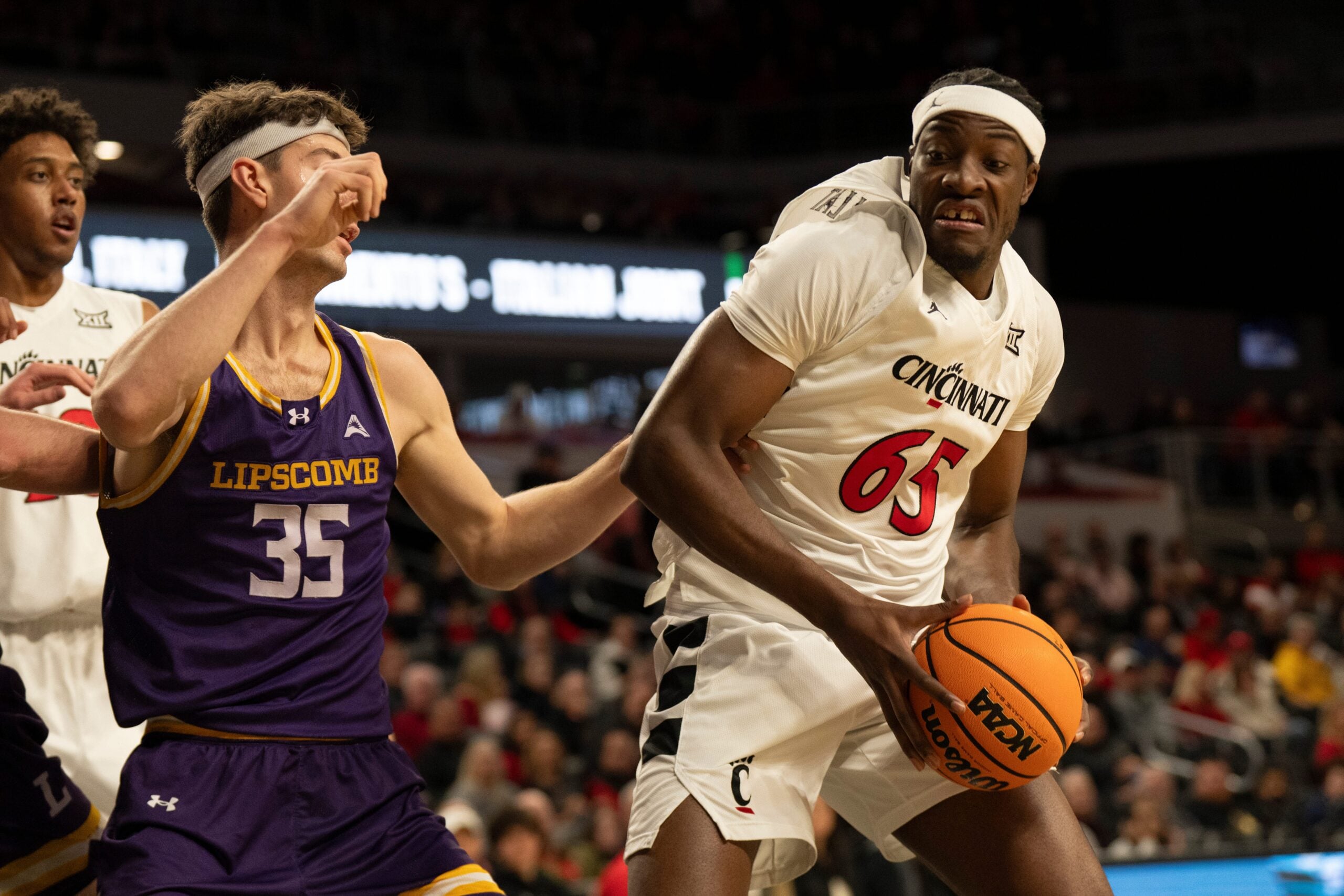 Cincinnati Bearcats center Halvine Dzellat (65) drives on Lipscomb Bisons forward Grant Asman (35) in the first half of the NCAA basketball game at Fifth Third Arena in Cincinnati on Dec. 29, 2025.