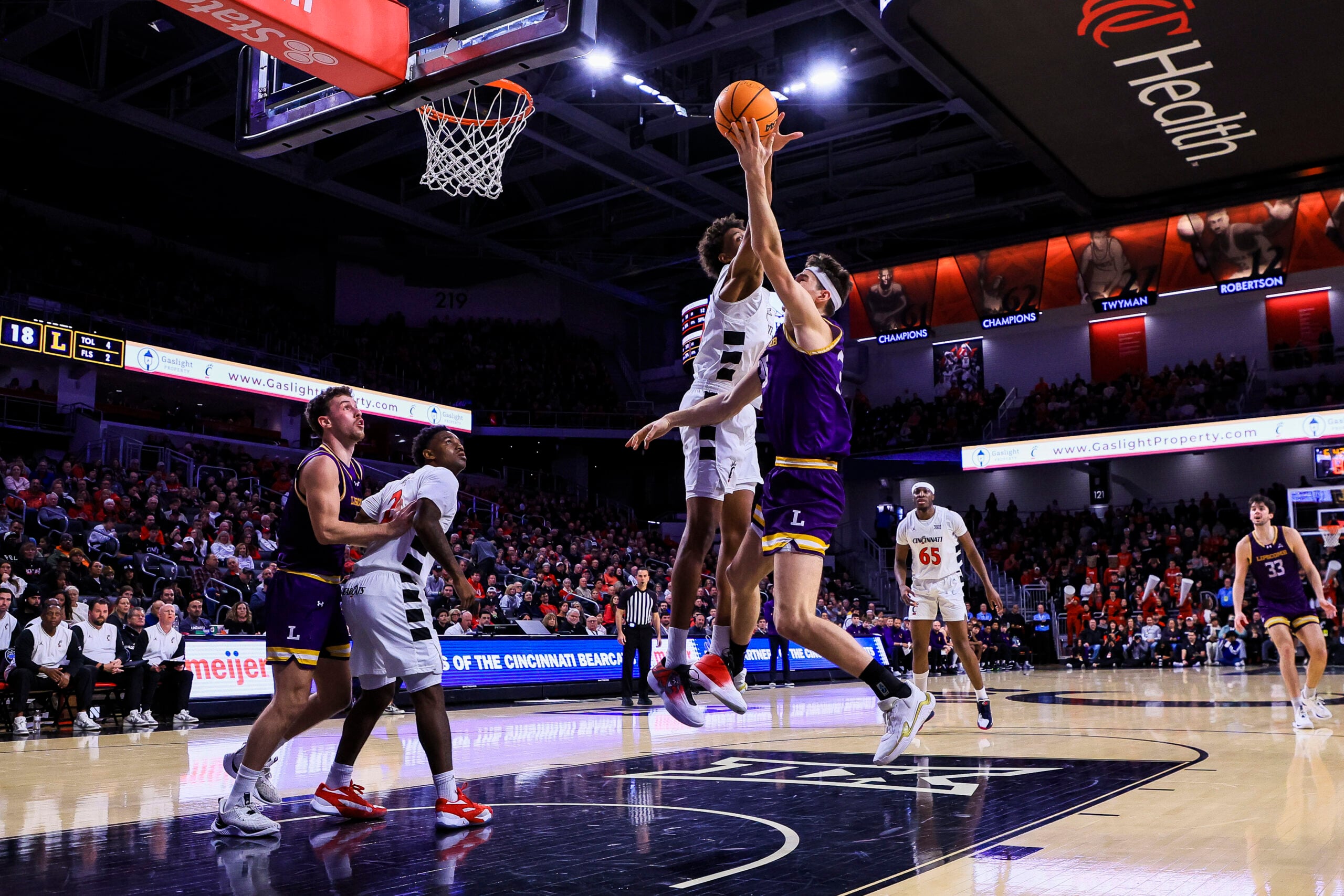 Dec 29, 2025; Cincinnati, Ohio, USA; Cincinnati Bearcats forward Baba Miller (18) blocks a shot by Lipscomb Bisons center Grant Asman (35) in the first half at Fifth Third Arena. Mandatory Credit: Katie Stratman-Imagn Images