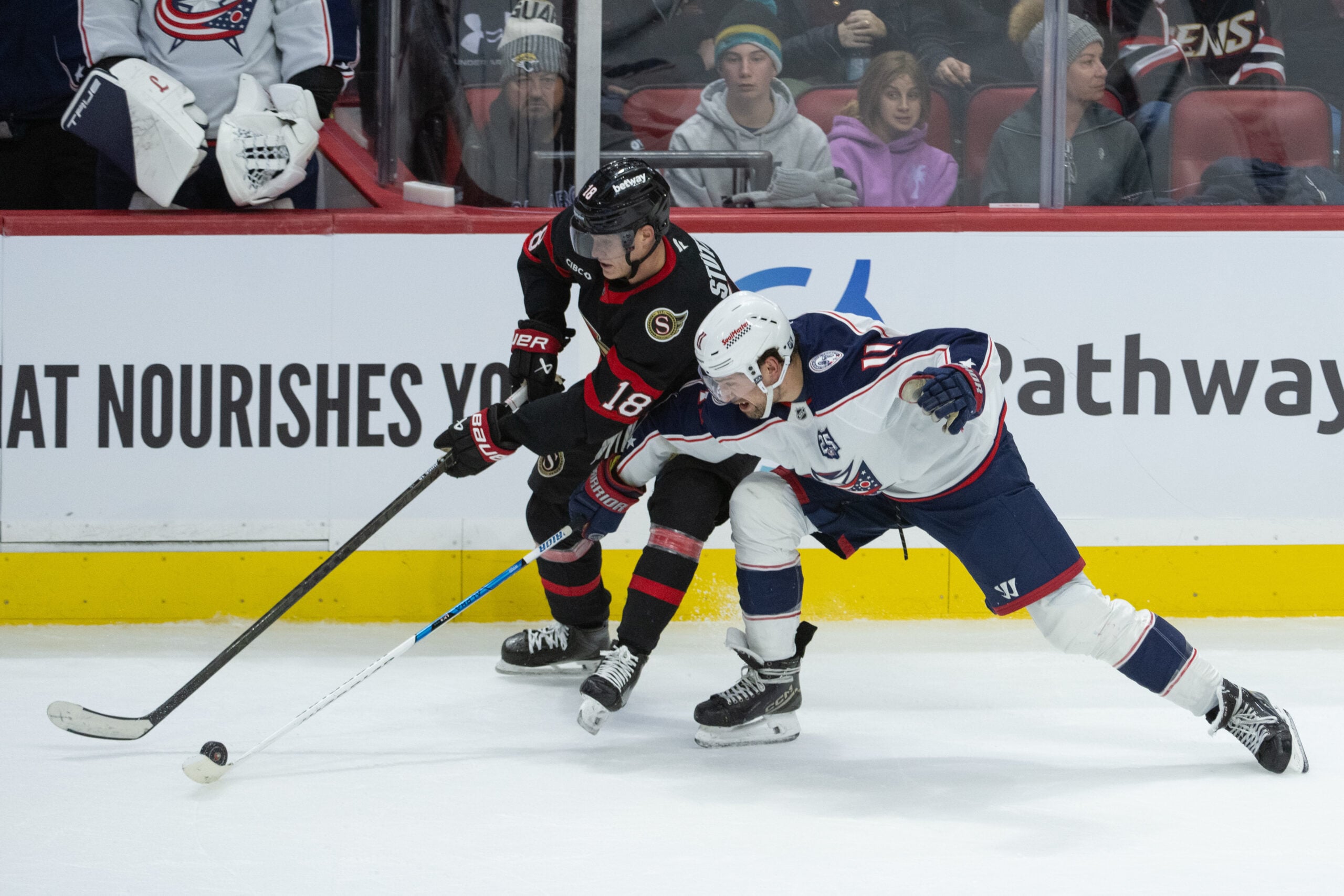 Dec 29, 2025; Ottawa, Ontario, CAN; Ottawa Senators center Tim Stutzle (18) battles with Columbus Blue Jackets left wing Miles Wood (11) for control of the puck in the third period at the Canadian Tire Centre. Mandatory Credit: Marc DesRosiers-IMAGN Images