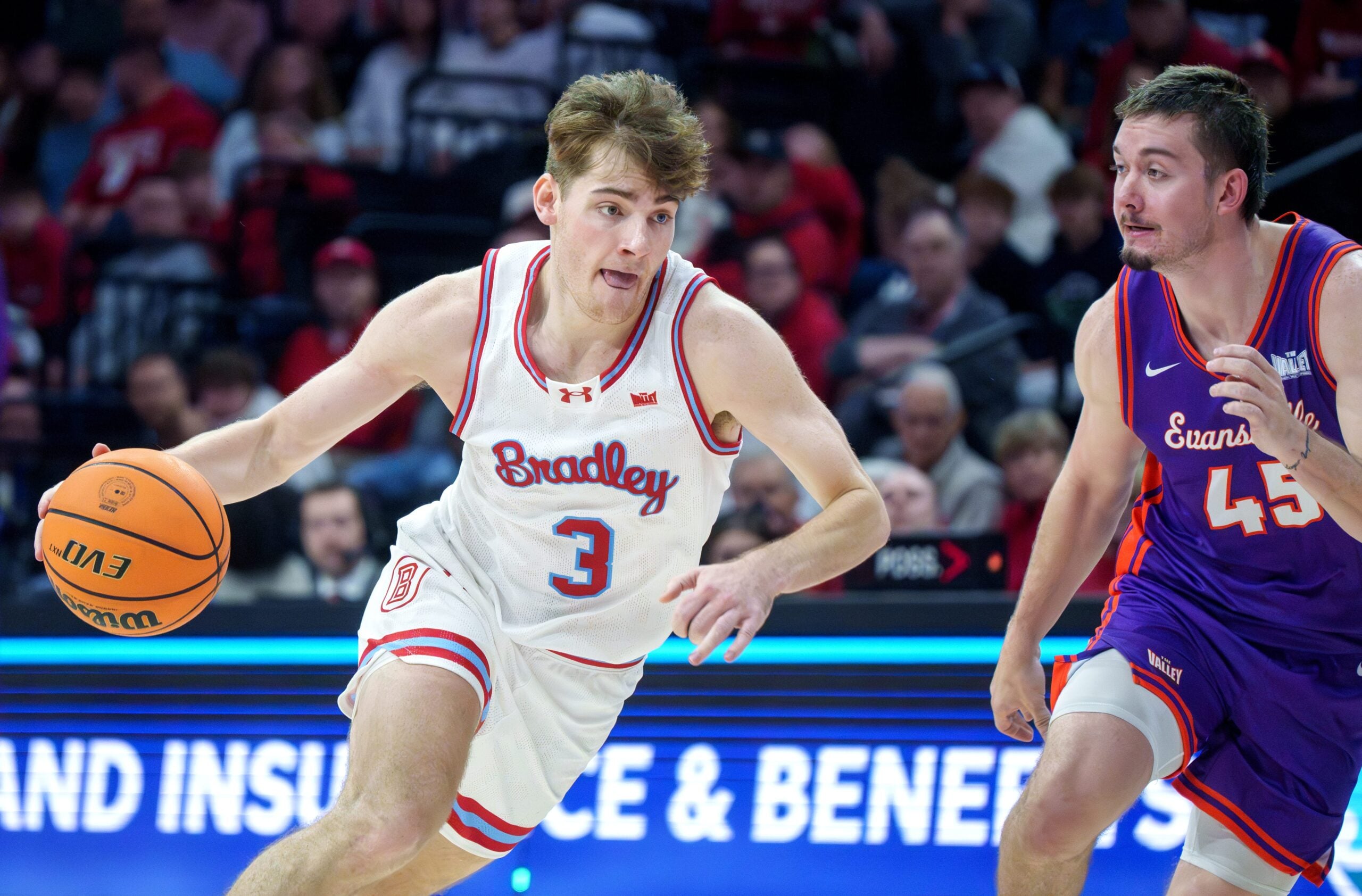 Bradley’s Alex Huibregtse moves the ball past Evansville’s Trent Hundley in the second half of their MVC college basketball game Monday, Dec. 29, 2025 at Carver Arena in Peoria. The Braves defeated the Aces 76-68.