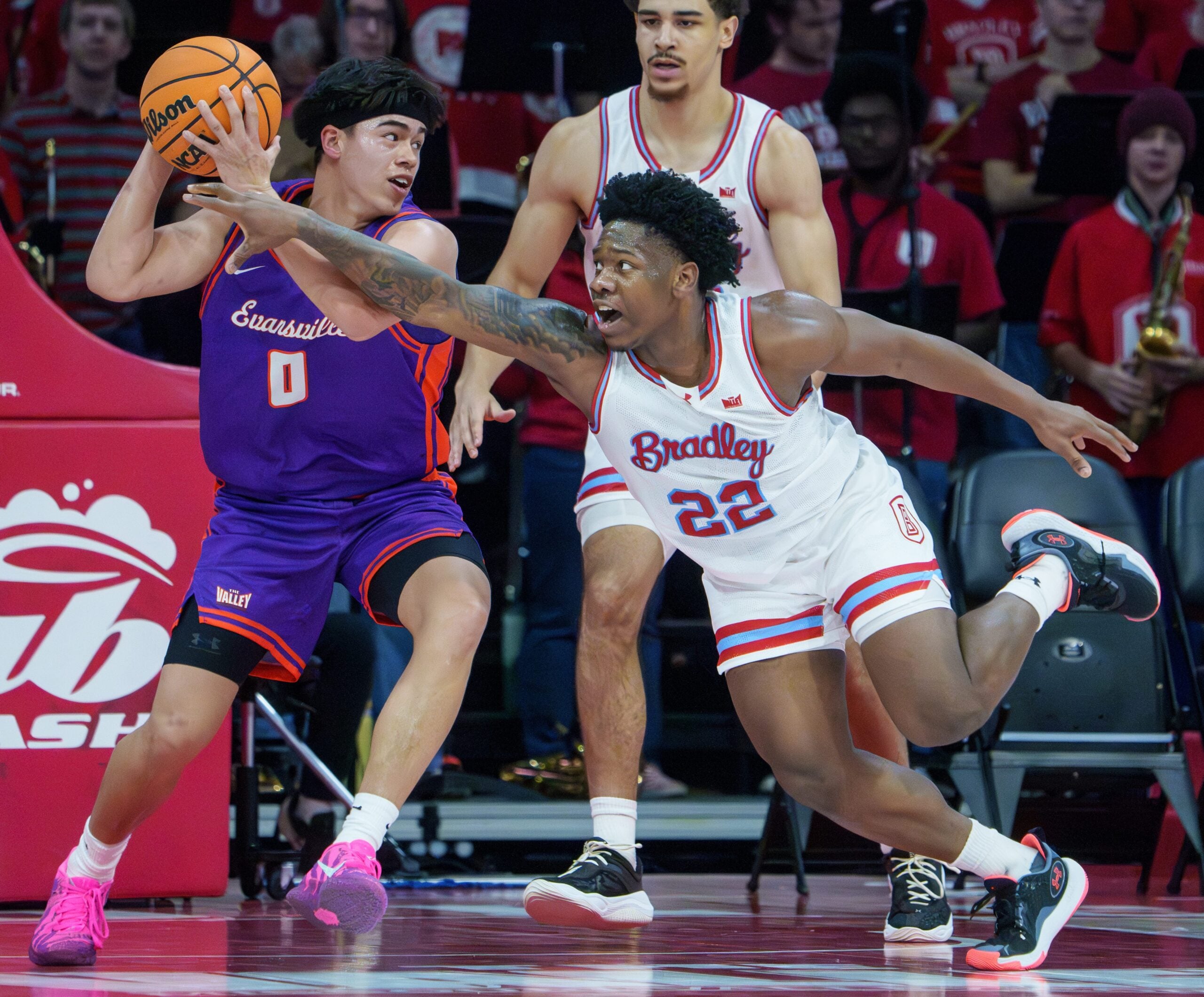 Bradley’s Jaquan Johnson (22) tries to knock the ball away from Evansville’s Bryce Quinet in the second half of their MVC college basketball game Monday, Dec. 29, 2025 at Carver Arena in Peoria. The Braves defeated the Aces 76-68.