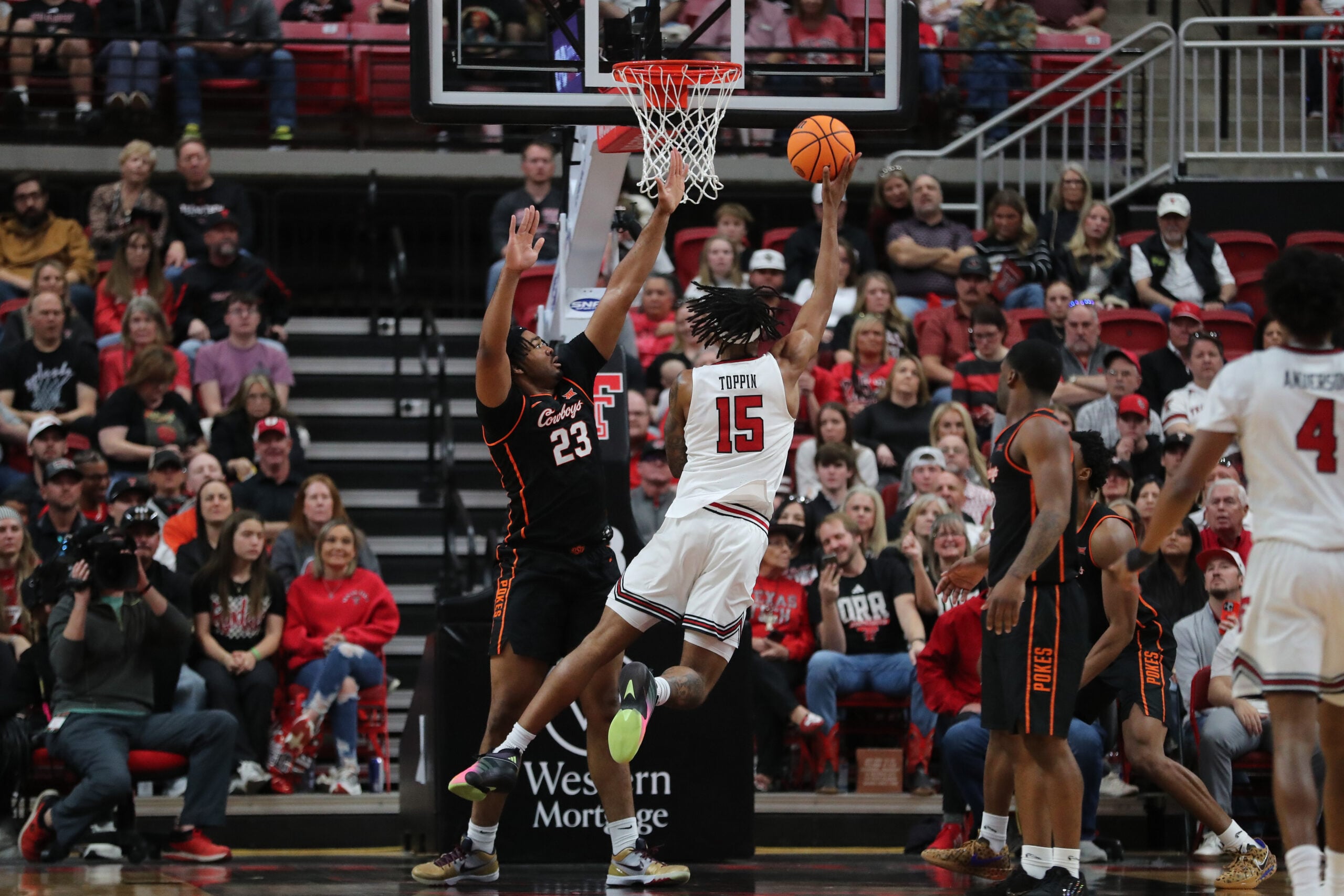 Jan 3, 2026; Lubbock, Texas, USA;  Texas Tech Red Raiders forward JT Toppin (15) takes a shot against Oklahoma State Cowboys center Benjamin Ahmed (23) in the second half at United Supermarkets Arena. Mandatory Credit: Michael C. Johnson-Imagn Images