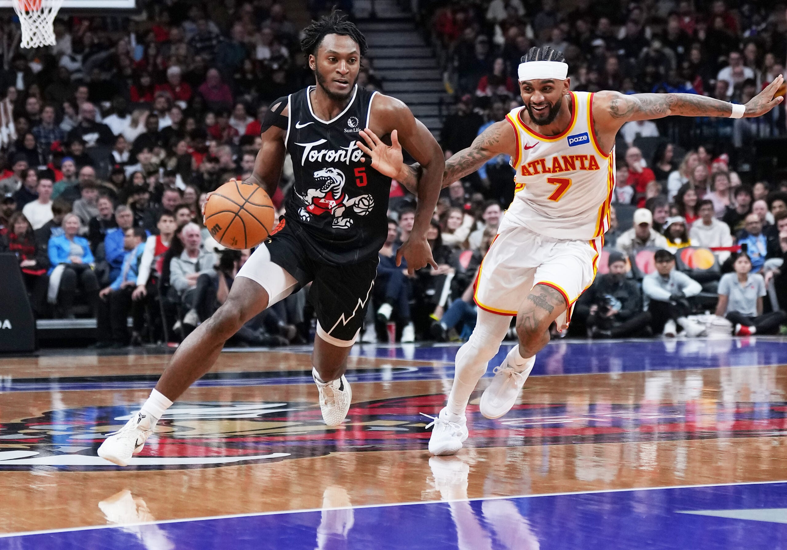 Jan 3, 2026; Toronto, Ontario, CAN; Toronto Raptors guard Immanuel Quickley (5) controls the ball as Atlanta Hawks guard Nickeil Alexander-Walker (7) tries to defend during the fourth quarter at Scotiabank Arena. Mandatory Credit: Nick Turchiaro-Imagn Images