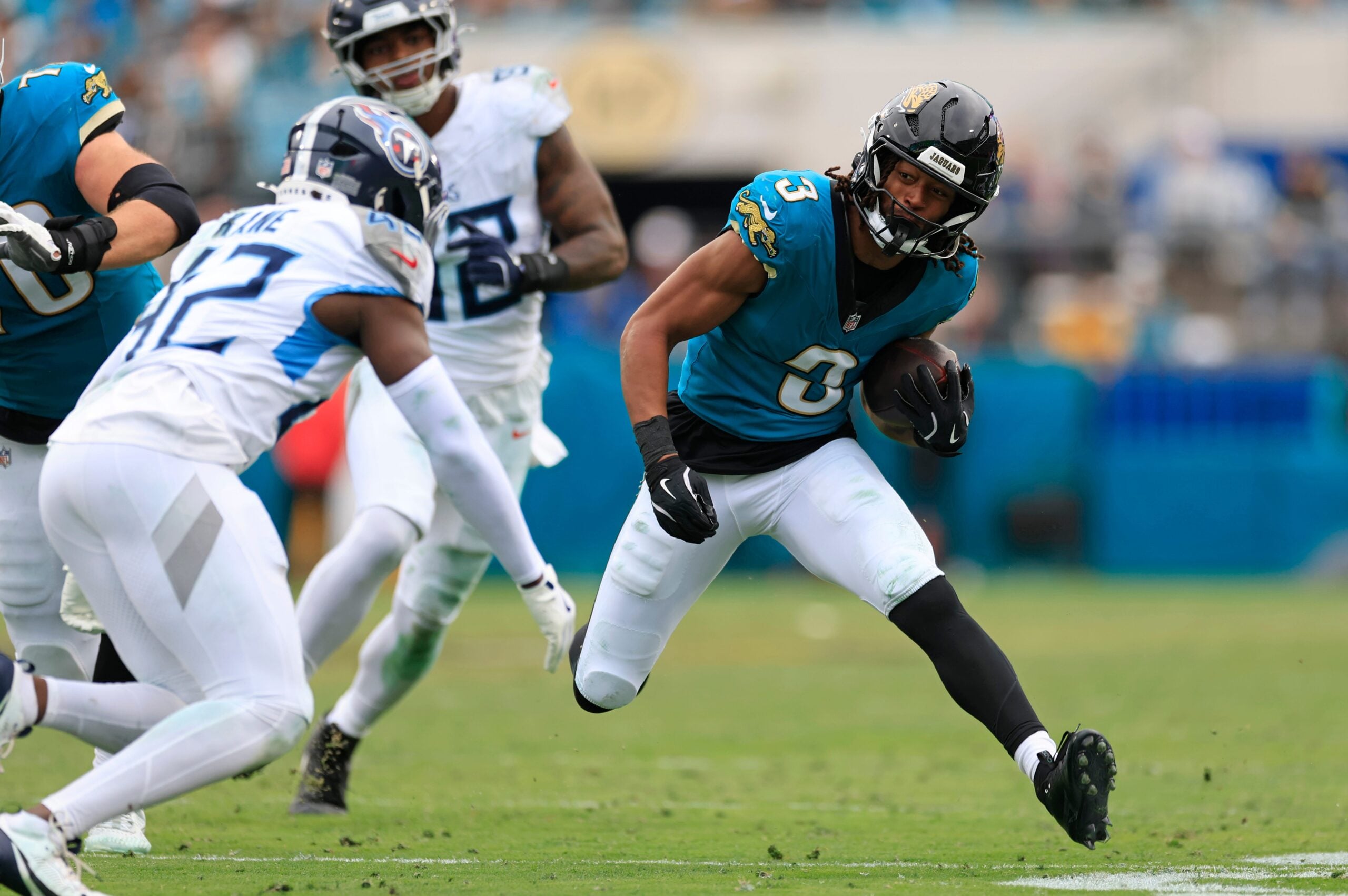 Jacksonville Jaguars wide receiver Jakobi Meyers (3) rushes for yards against Tennessee Titans safety Sanoussi Kane (42) during the fourth quarter of an NFL football matchup at EverBank Stadium, Sunday, Jan. 4, 2026, in Jacksonville, Fla. The Jaguars defeated the Titans 41-7, capturing the AFC South title. [Corey Perrine/Florida Times-Union]