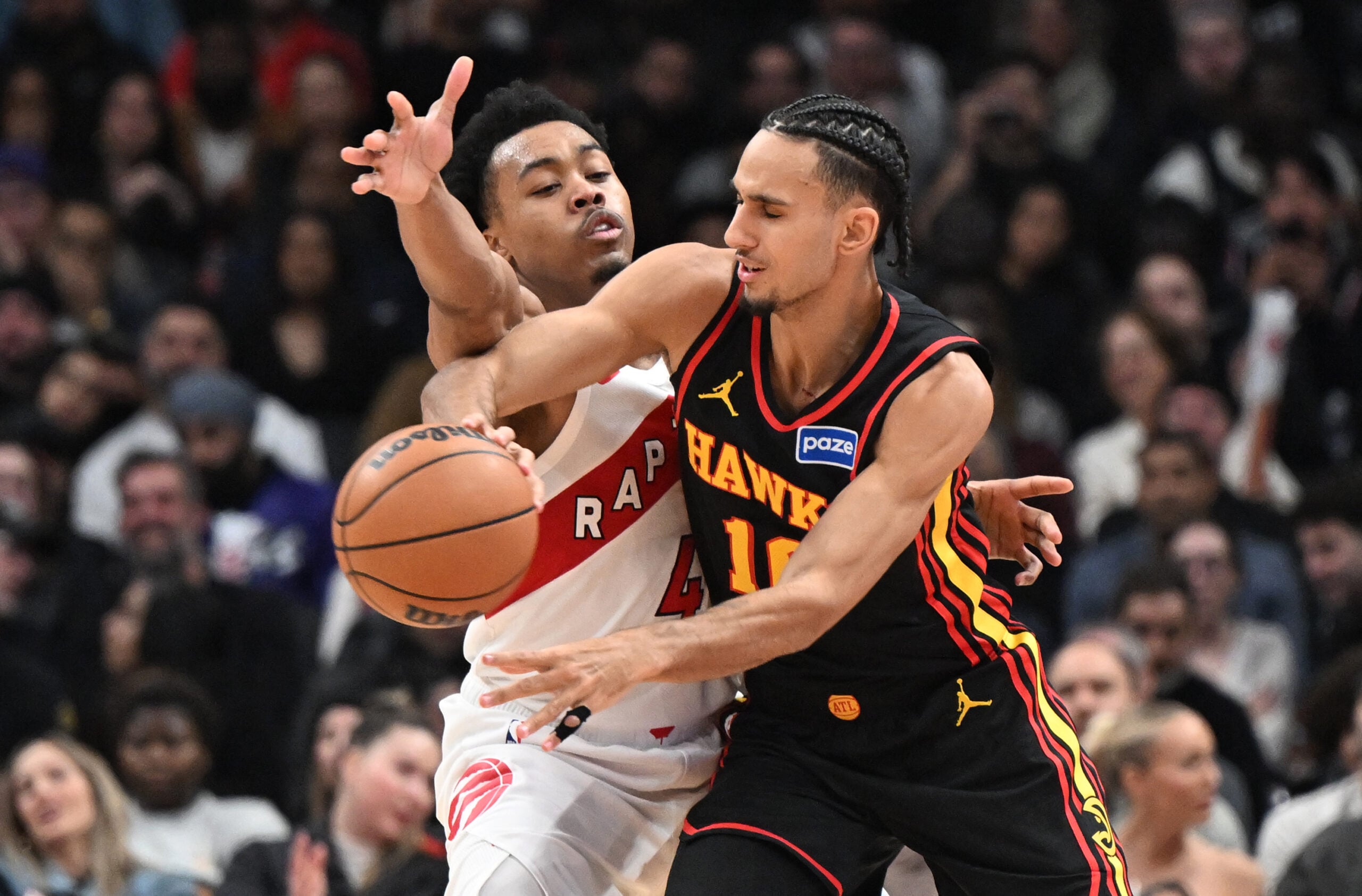Jan 5, 2026; Toronto, Ontario, CAN; Atlanta Hawks forward Zaccharie Risacher (10) passes the ball away from Toronto Raptors forward Scottie Barnes (4) in the second half at Scotiabank Arena. Mandatory Credit: Dan Hamilton-Imagn Images
