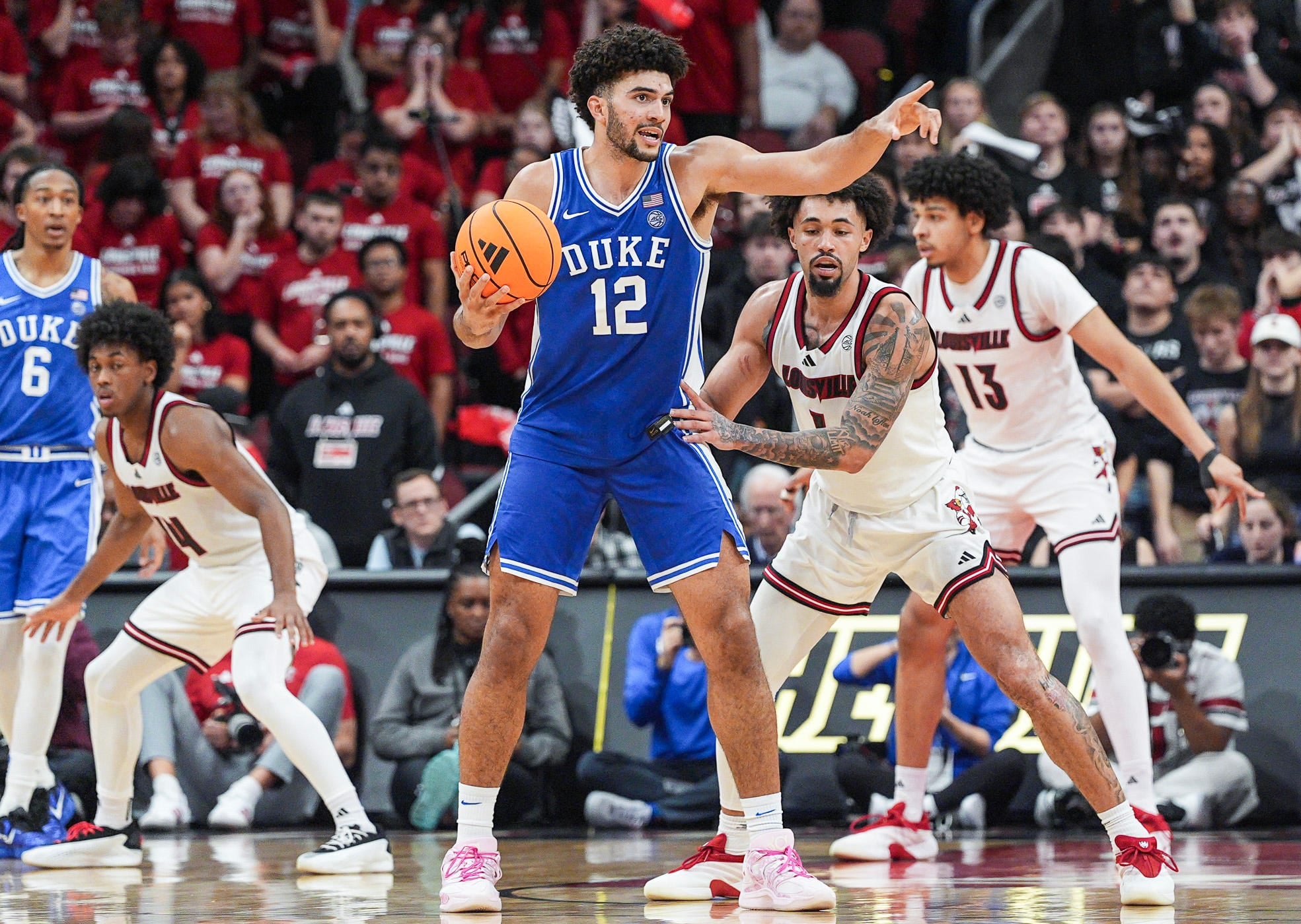 Duke Blue Devils forward Cameron Boozer (12) directs a play as Louisville Cardinals guard J'vonne Hadley (1) guards during a conference ACC game. January 6, 2026.