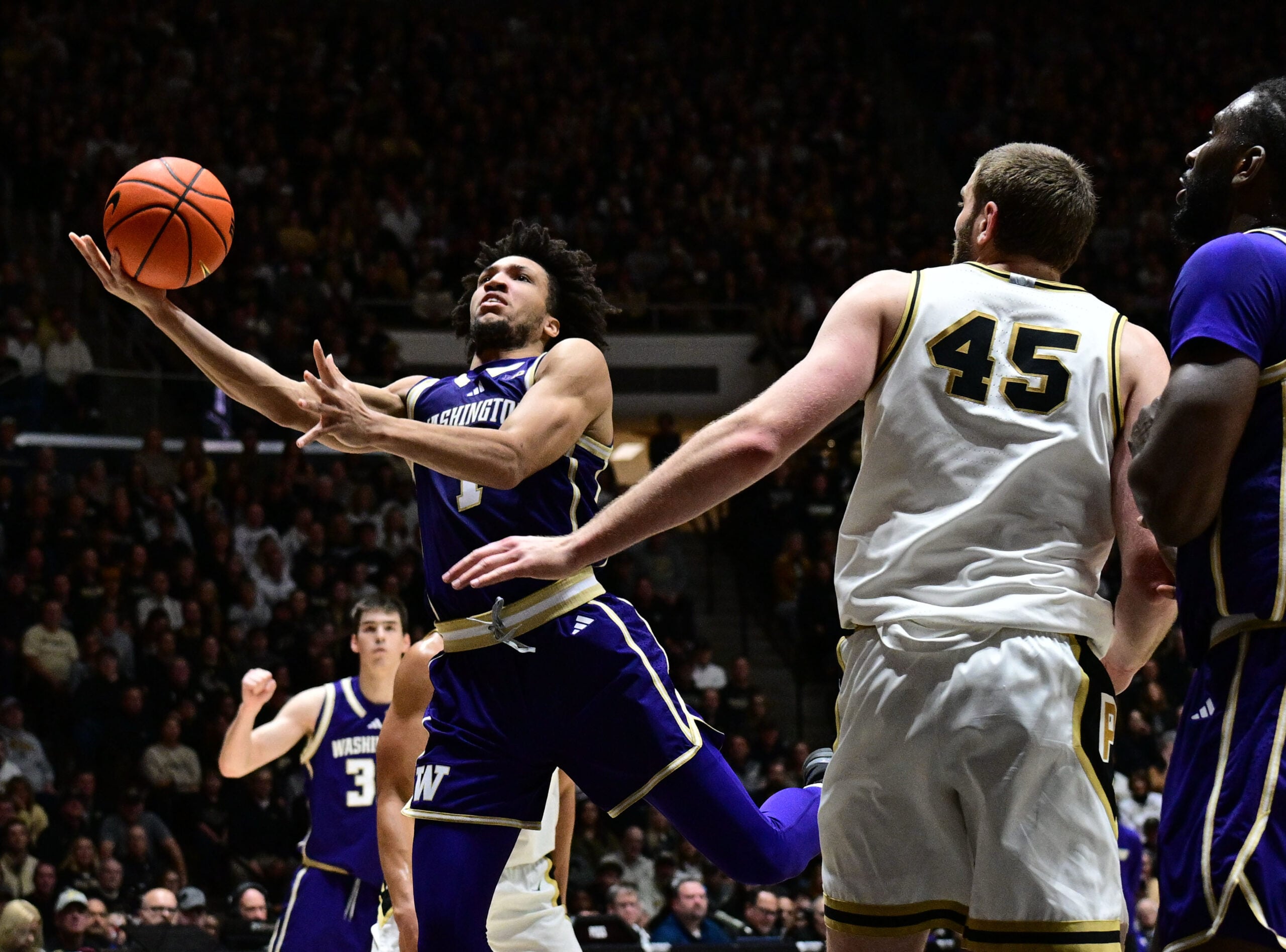 Jan 7, 2026; West Lafayette, Indiana, USA; Washington Huskies guard Desmond Claude (1) shoots the ball in front of Purdue Boilermakers center Oscar Cluff (45) during the first half at Mackey Arena. Mandatory Credit: Marc Lebryk-Imagn Images