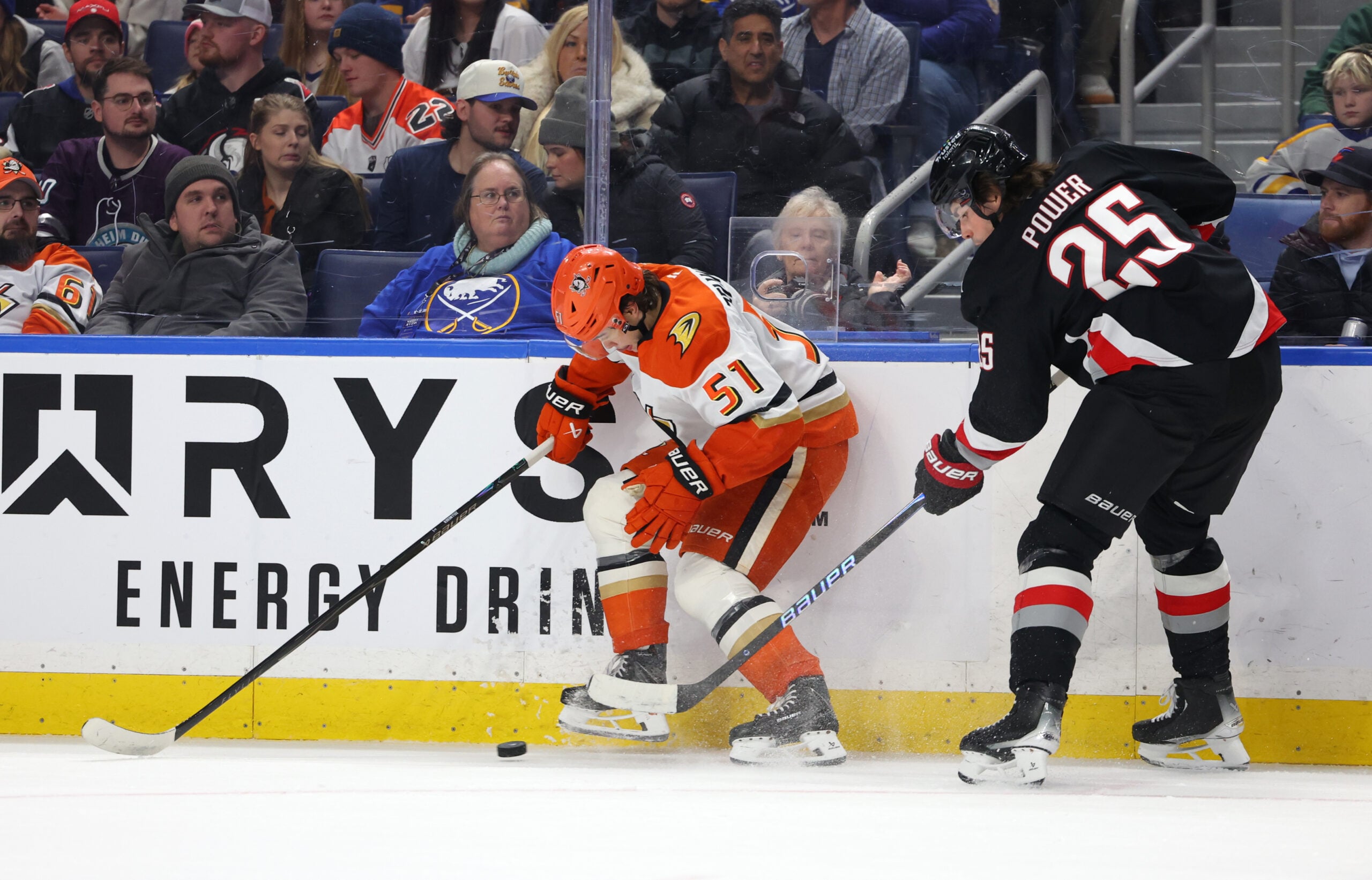 Jan 10, 2026; Buffalo, New York, USA;  Anaheim Ducks defenseman Olen Zellweger (51) tries to control the puck as Buffalo Sabres defenseman Owen Power (25) defends during the first period at KeyBank Center. Mandatory Credit: Timothy T. Ludwig-Imagn Images