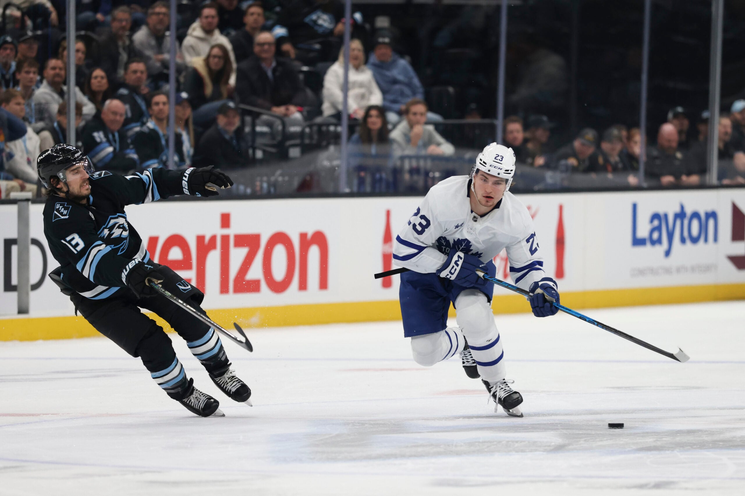 Jan 13, 2026; Salt Lake City, Utah, USA; Toronto Maple Leafs left wing Matthew Knies (23) skates with the puck against Utah Mammoth left wing Brandon Tanev (13) during the first period at Delta Center. Mandatory Credit: Rob Gray-Imagn Images
