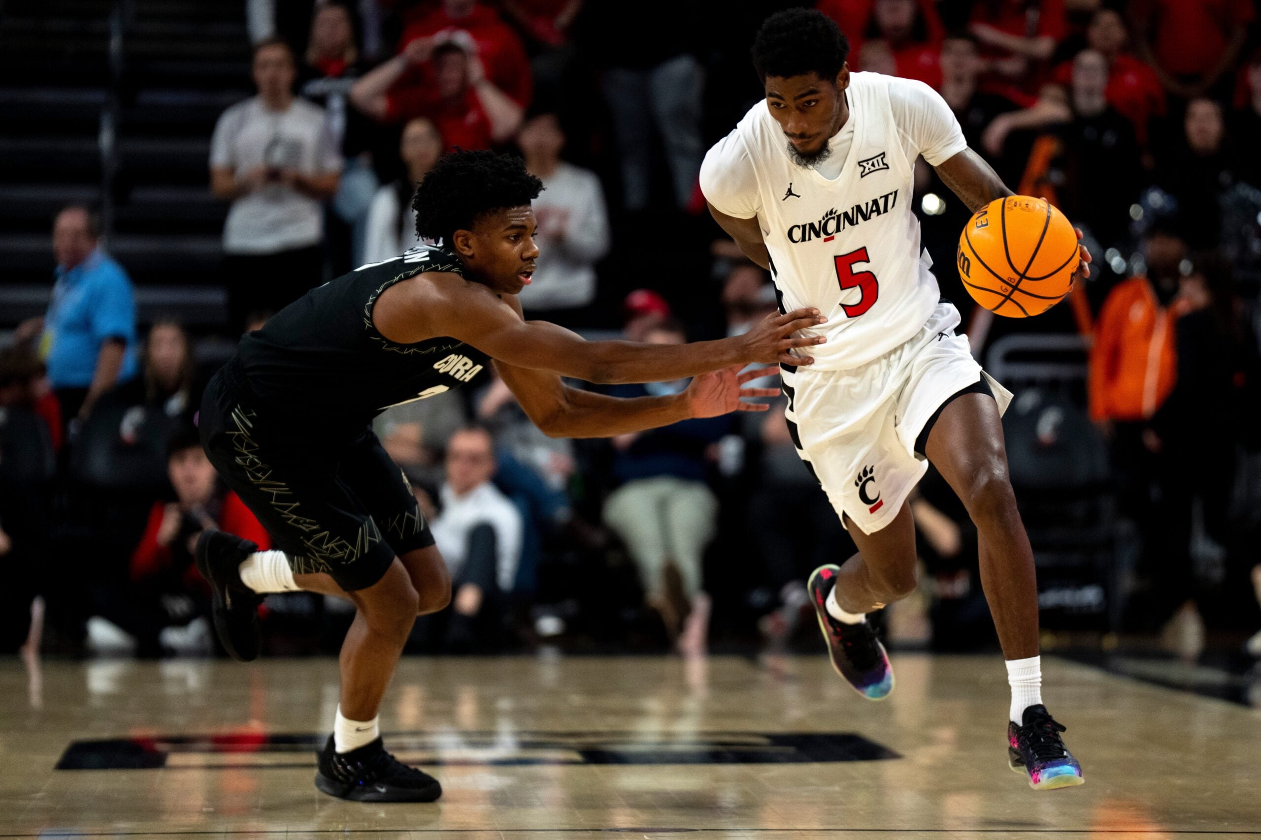 Colorado Buffaloes guard Isaiah Johnson (2) fouls Cincinnati Bearcats guard Sencire Harris (5) in the second half of the NCAA Basketball game at Fifth Third Arena in Cincinnati on Jan. 14, 2026.