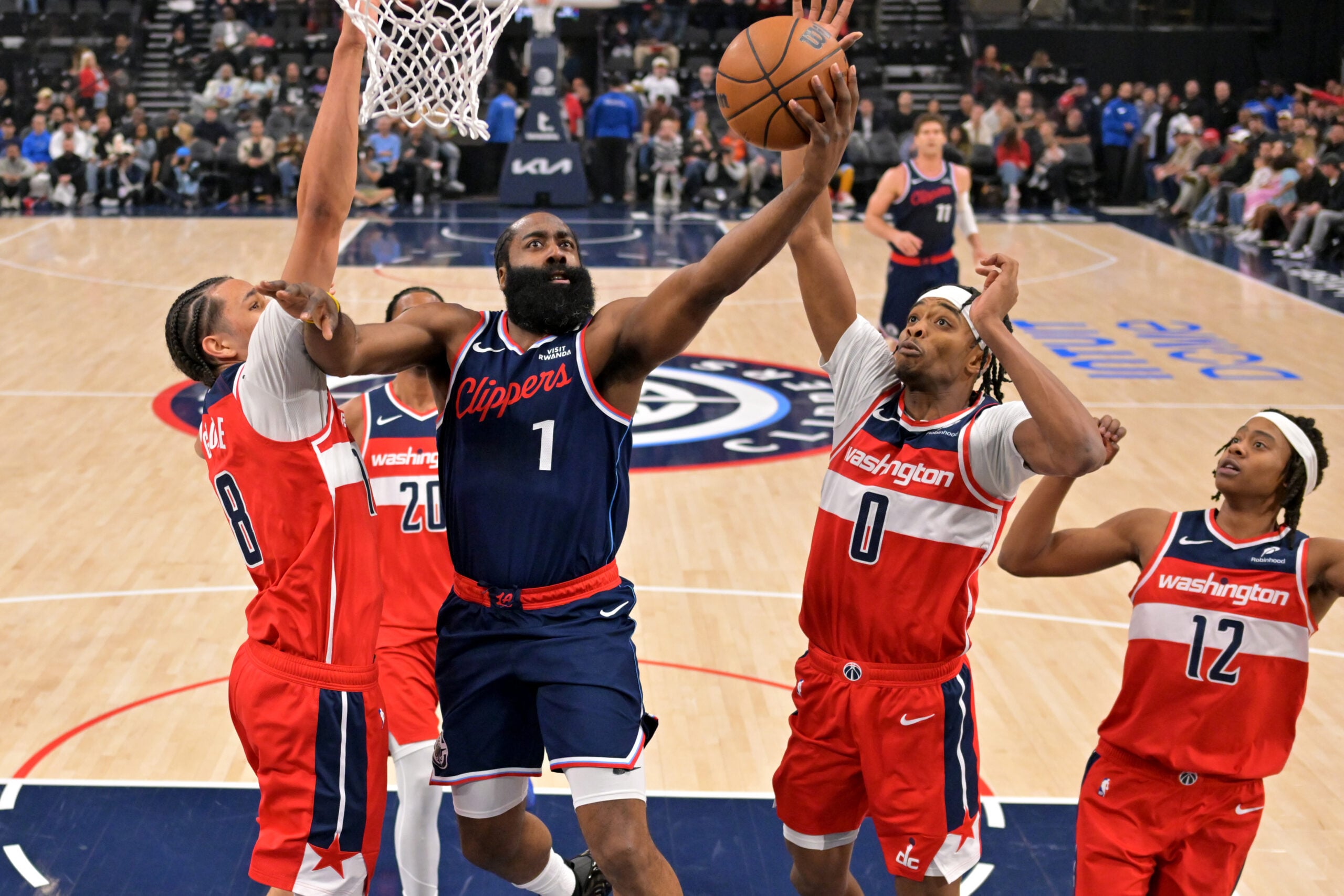 Jan 14, 2026; Inglewood, California, USA;  Los Angeles Clippers guard James Harden (1) drives to the basket past Washington Wizards guard Malaki Branham (8) and guard Bilal Coulibaly (0) in the first half at Intuit Dome. Mandatory Credit: Jayne Kamin-Oncea-Imagn Images