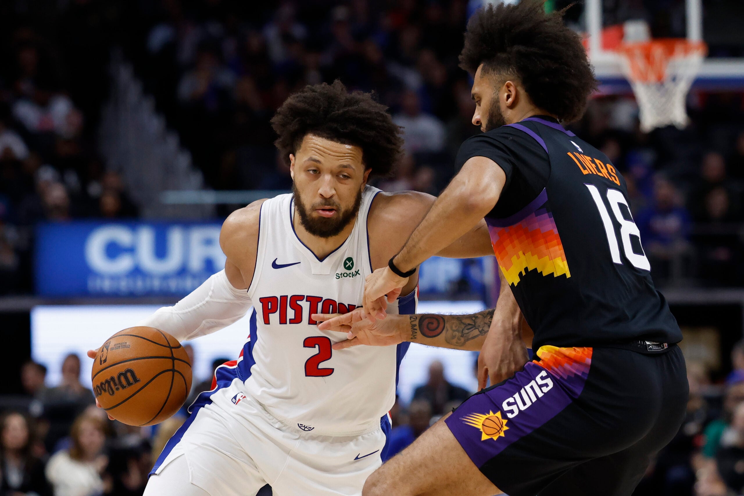 Jan 15, 2026; Detroit, Michigan, USA;  Detroit Pistons guard Cade Cunningham (2) dribbles defended by Phoenix Suns forward Isaiah Livers (18) in the second half at Little Caesars Arena. Mandatory Credit: Rick Osentoski-Imagn Images