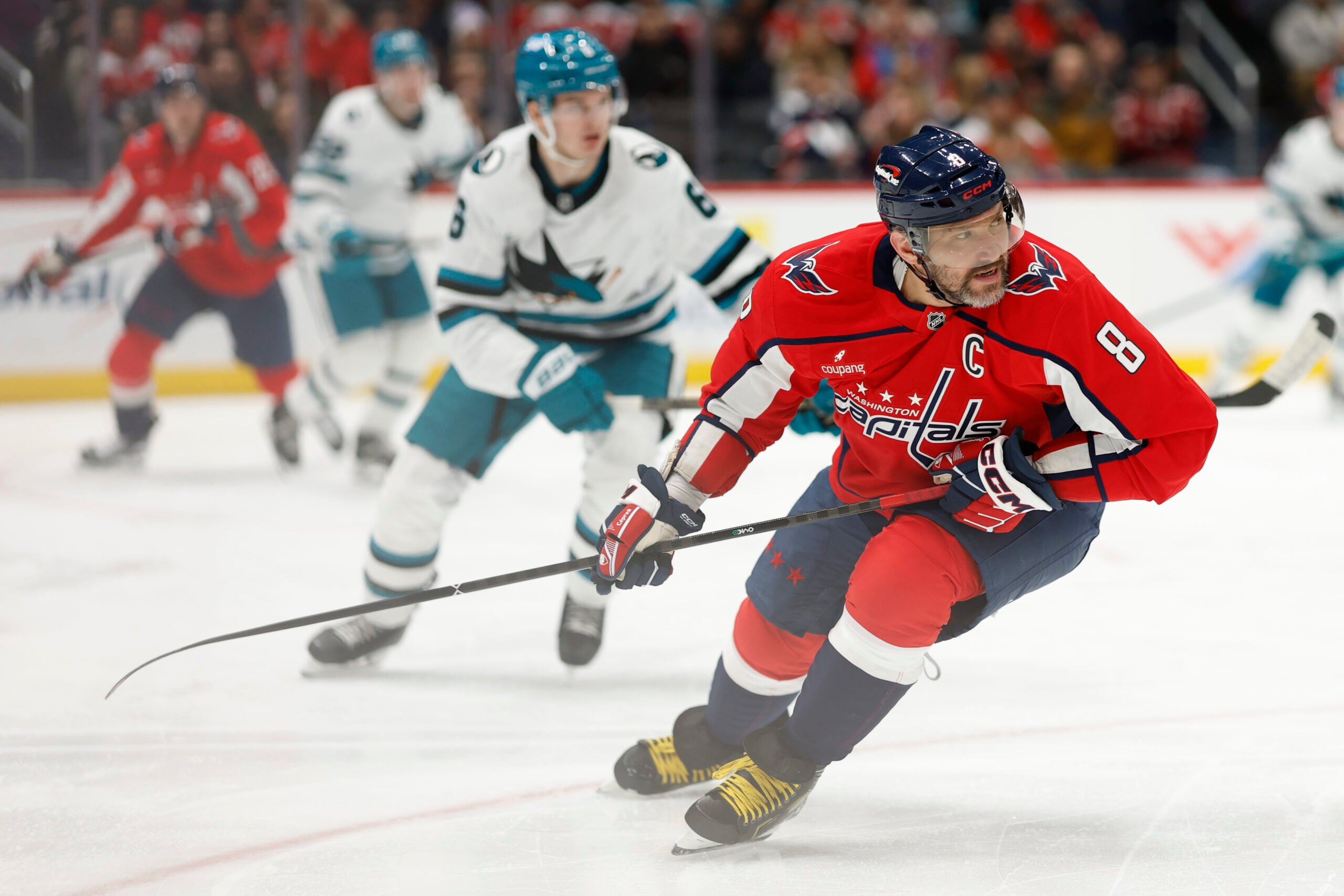 Jan 15, 2026; Washington, District of Columbia, USA; Washington Capitals left wing Alex Ovechkin (8) and San Jose Sharks defenseman Sam Dickinson (6) chase the puck during the third period at Capital One Arena. Mandatory Credit: Geoff Burke-Imagn Images