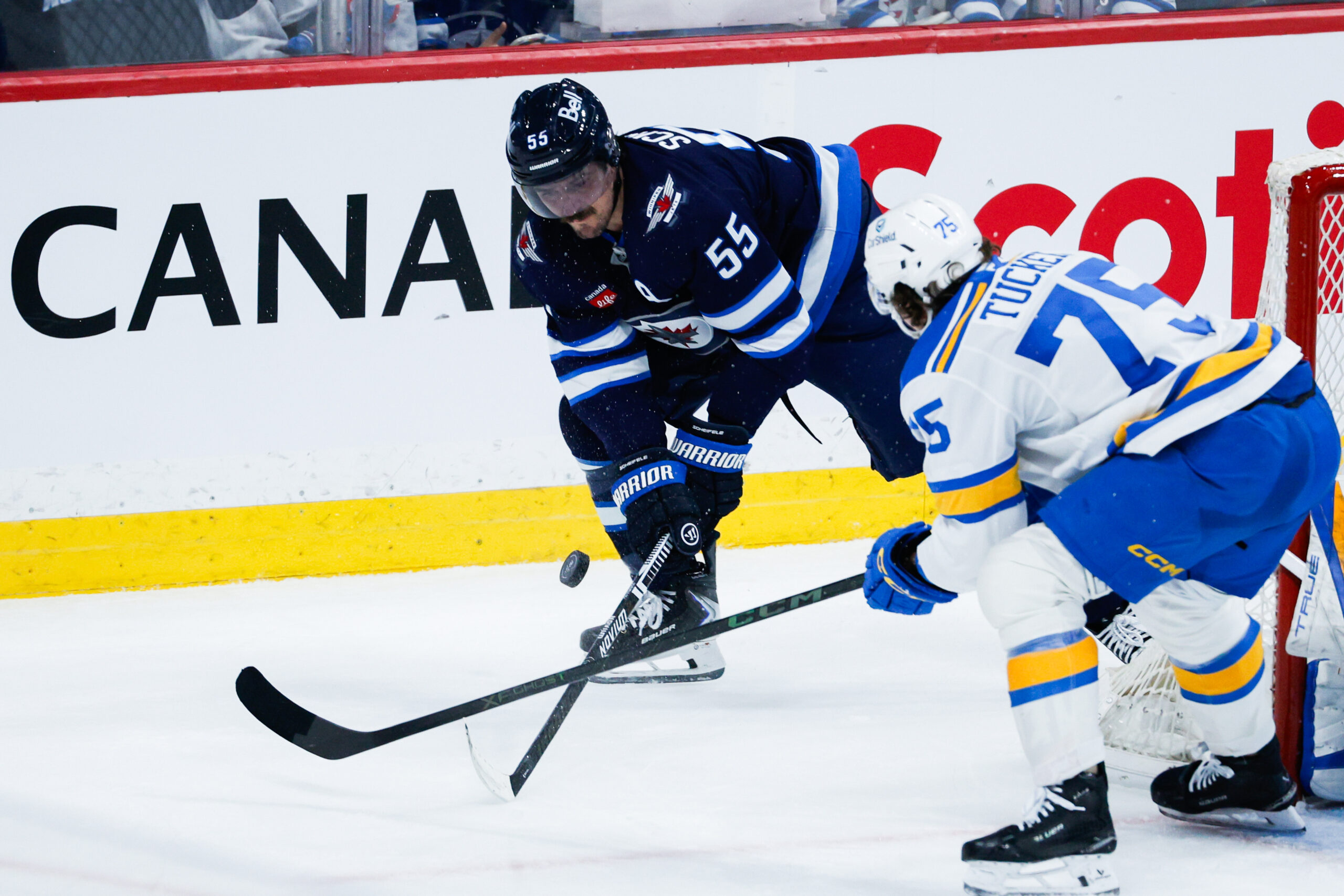 Jan 20, 2026; Winnipeg, Manitoba, CAN; Winnipeg Jets forward Mark Scheifele (55) and St. Louis Blues defenseman Tyler Tucker (75) contest for the puck during the third period at Canada Life Centre. Mandatory Credit: Terrence Lee-Imagn Images