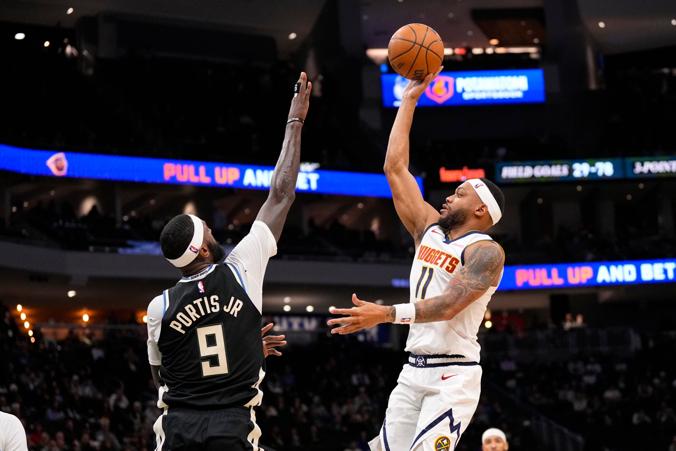 Jan 23, 2026; Milwaukee, Wisconsin, USA; Denver Nuggets guard Bruce Brown (11) shoots over Milwaukee Bucks forward Bobby Portis (9) during the fourth quarter at Fiserv Forum. Mandatory Credit: Jeff Hanisch-Imagn Images