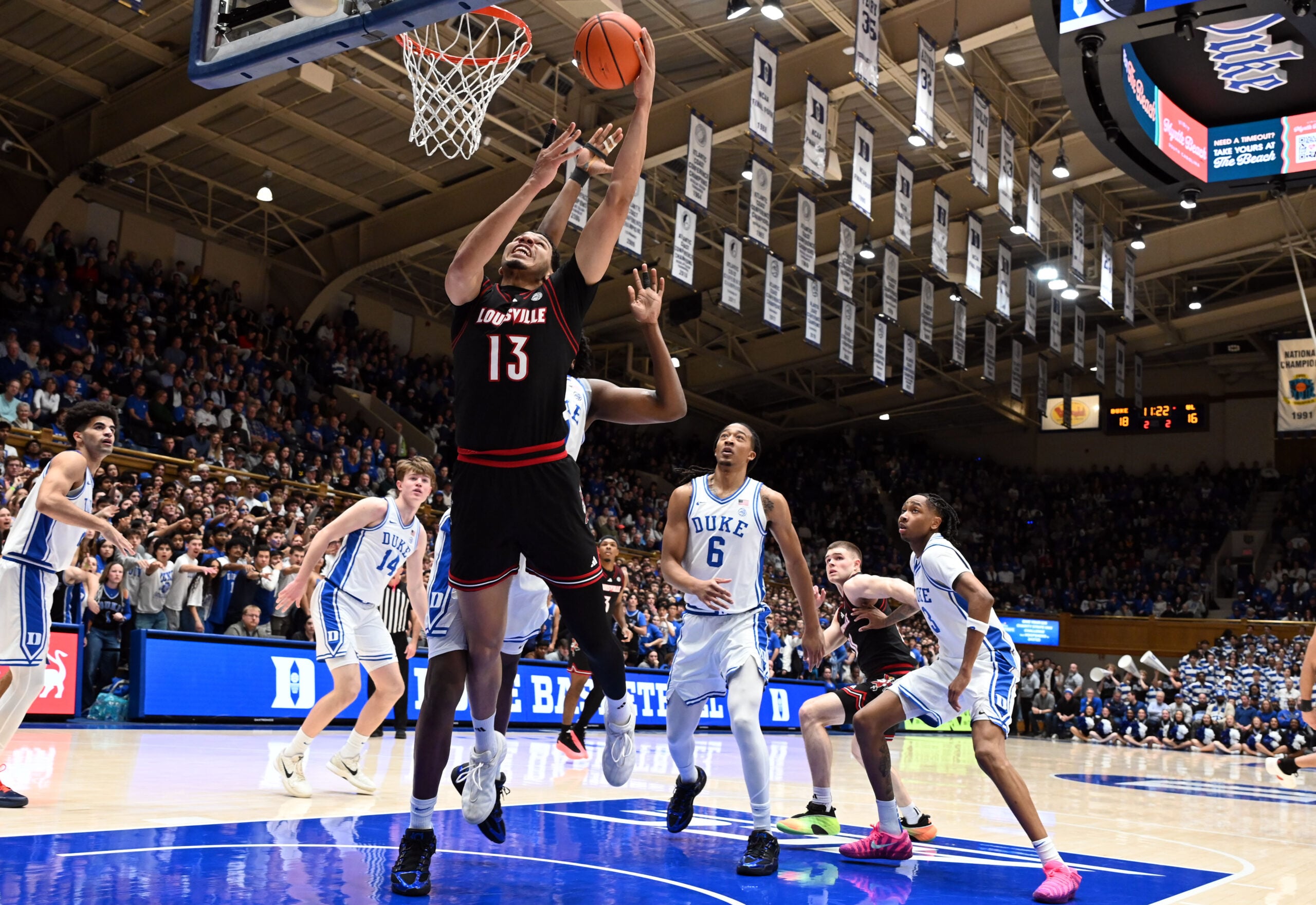 Jan 26, 2026; Durham, North Carolina, USA; Louisville Cardinals center Sananda Fru (13) lays the ball up in front of Duke Blue Devils center Patrick Ngongba II (21) during the first half at Cameron Indoor Stadium. Mandatory Credit: Rob Kinnan-Imagn Images
