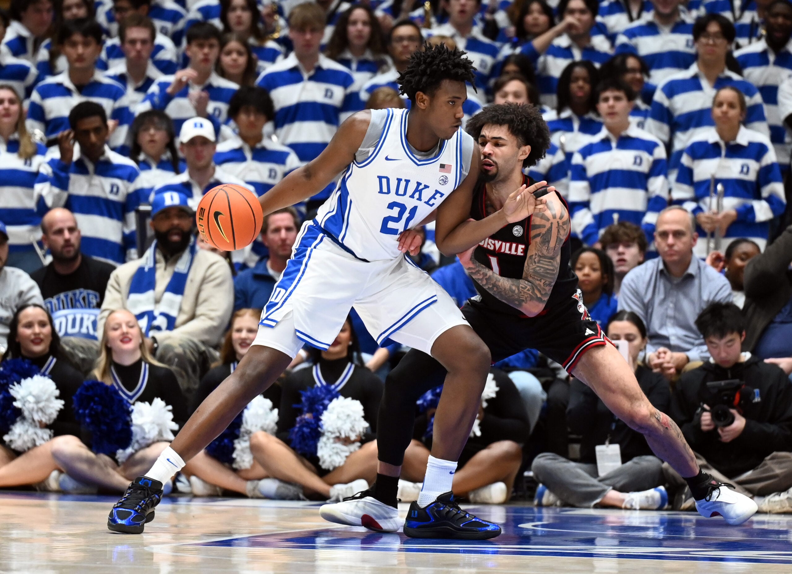 Jan 26, 2026; Durham, North Carolina, USA; Duke Blue Devils center Patrick Ngongba II (21) drives to the basket as Louisville Cardinals guard J'Vonne Hadley (1) defends during the first half at Cameron Indoor Stadium. Mandatory Credit: Rob Kinnan-Imagn Images