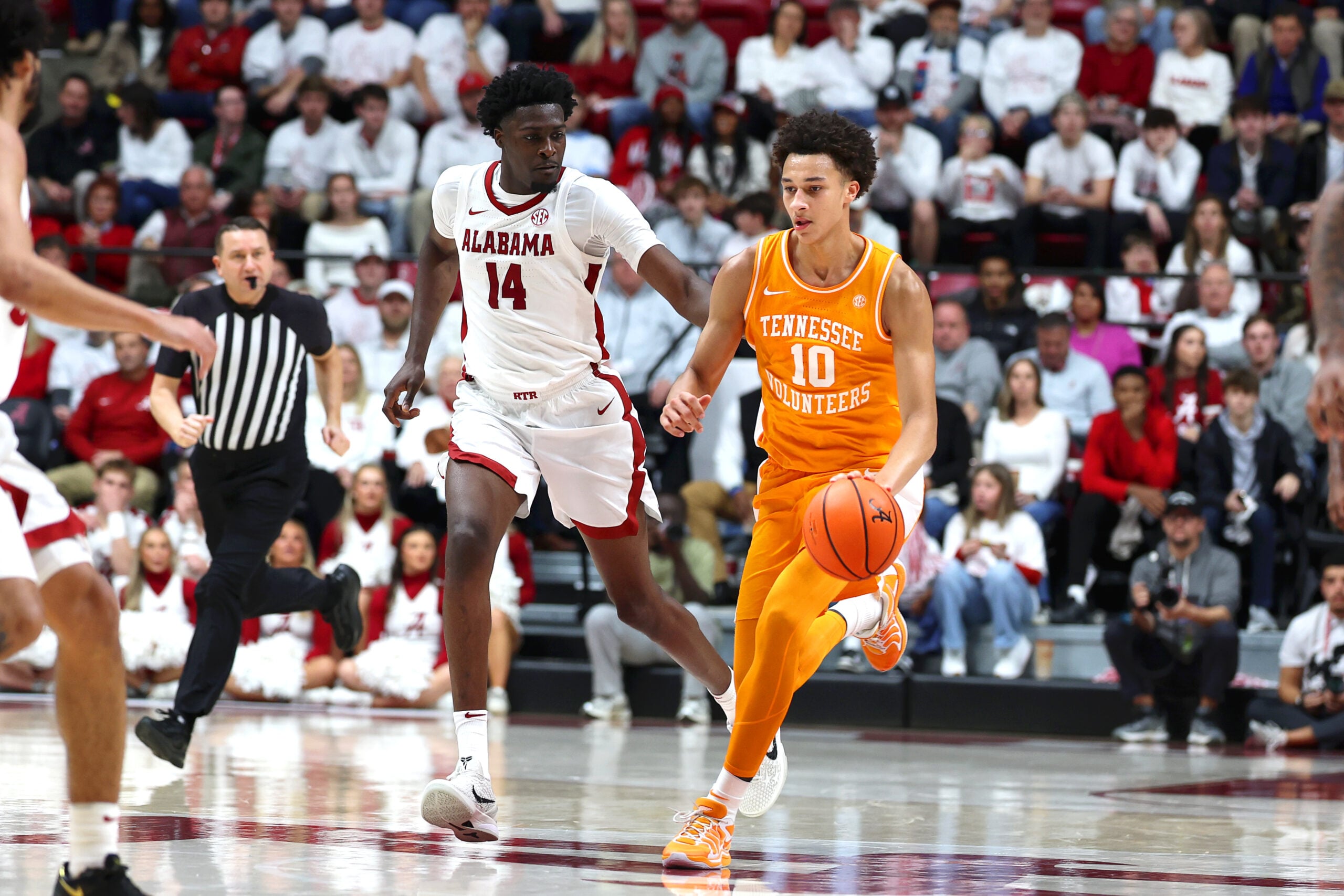 Jan 24, 2026; Tuscaloosa, Alabama, USA; Tennessee Volunteers forward Nate Ament (10) dribbles past Alabama Crimson Tide center Charles Bediako (14) during the first half at Coleman Coliseum. Mandatory Credit: David Leong-Imagn Images