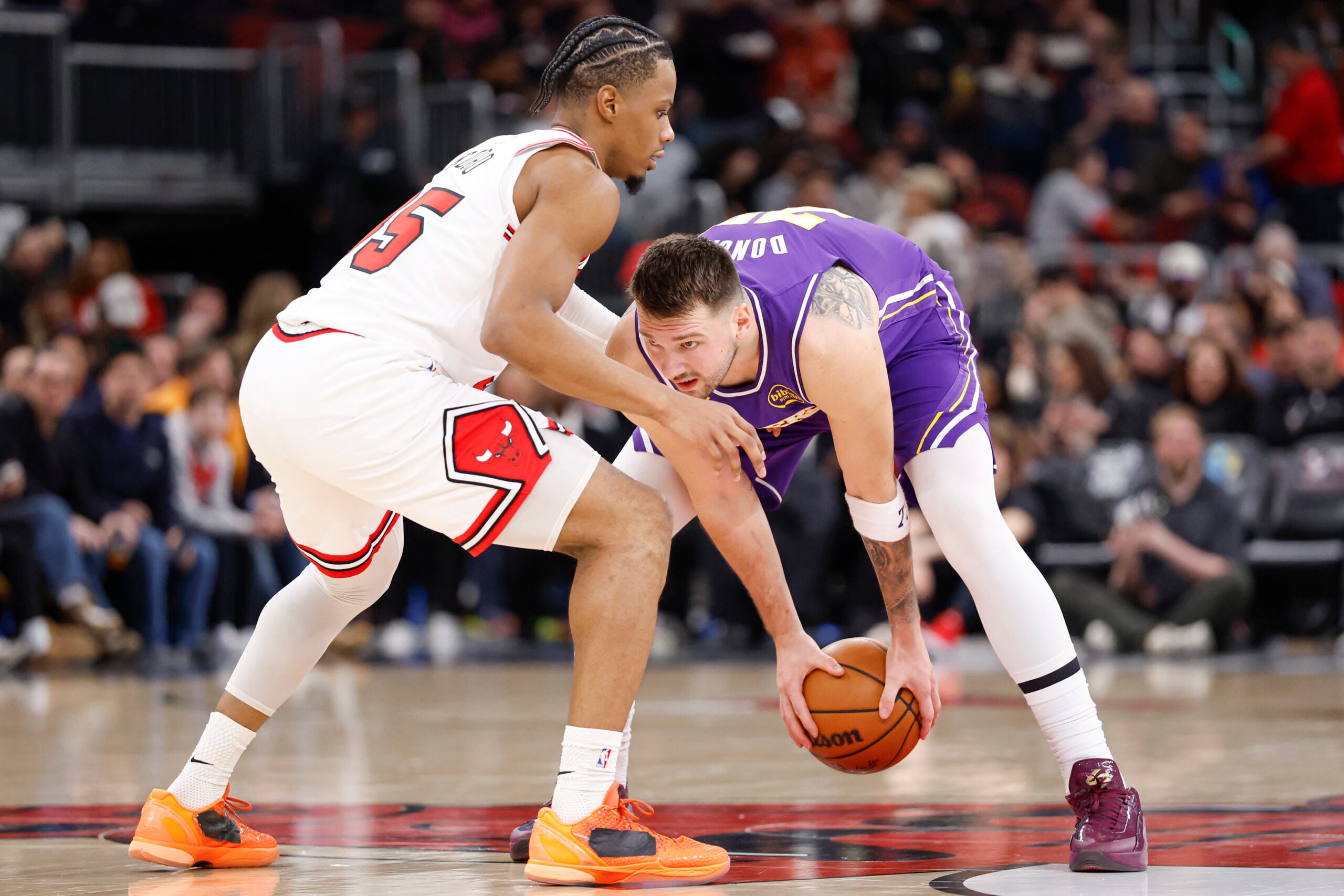 Jan 26, 2026; Chicago, Illinois, USA; Chicago Bulls forward Isaac Okoro (35) defends against Los Angeles Lakers guard Luka Doncic (77) during the second half at United Center. Mandatory Credit: Kamil Krzaczynski-Imagn Images