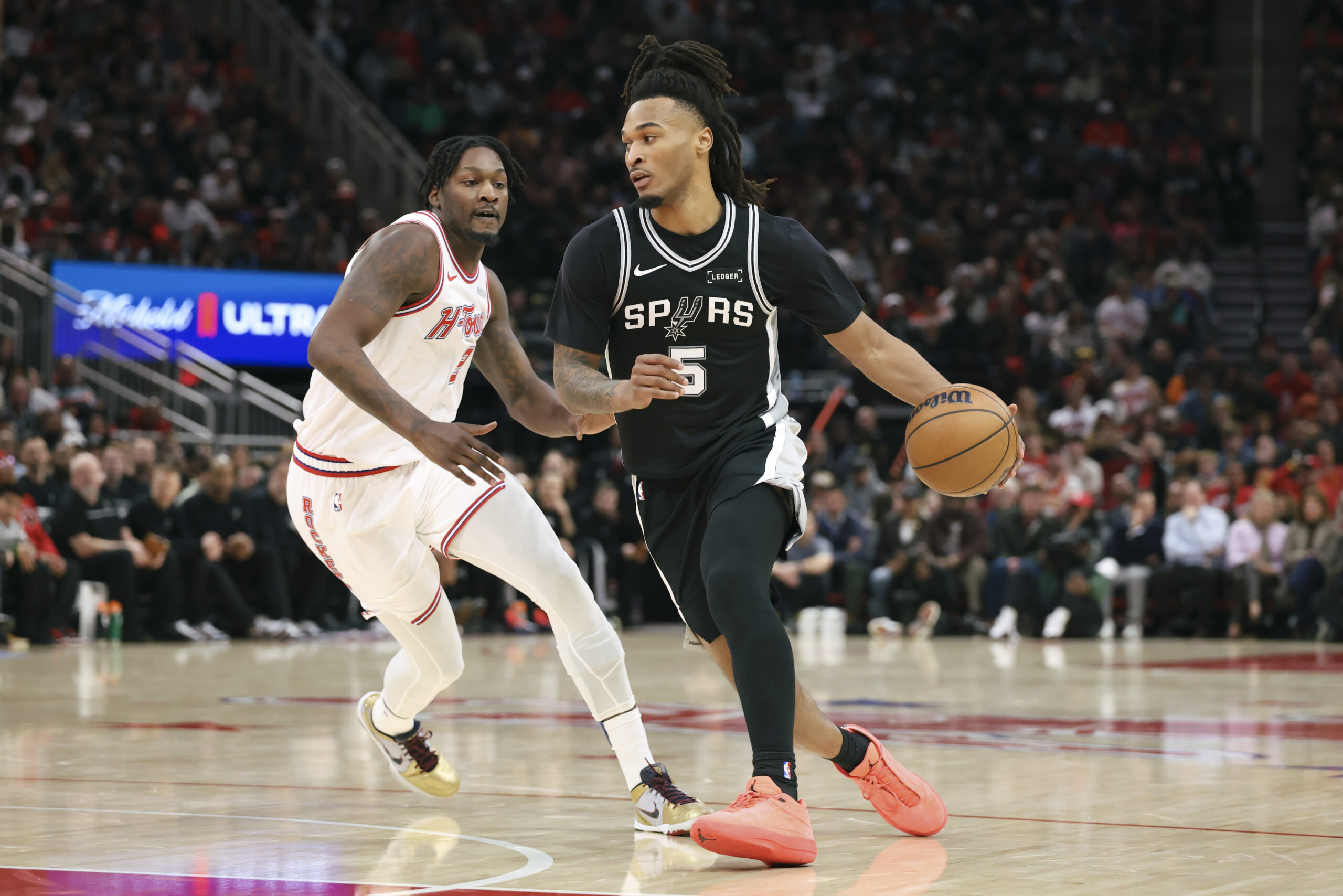 Jan 28, 2026; Houston, Texas, USA; San Antonio Spurs guard Stephon Castle (5) dribbles the ball as Houston Rockets forward Dorian Finney-Smith (2) defends during the third quarter at Toyota Center. Mandatory Credit: Troy Taormina-Imagn Images