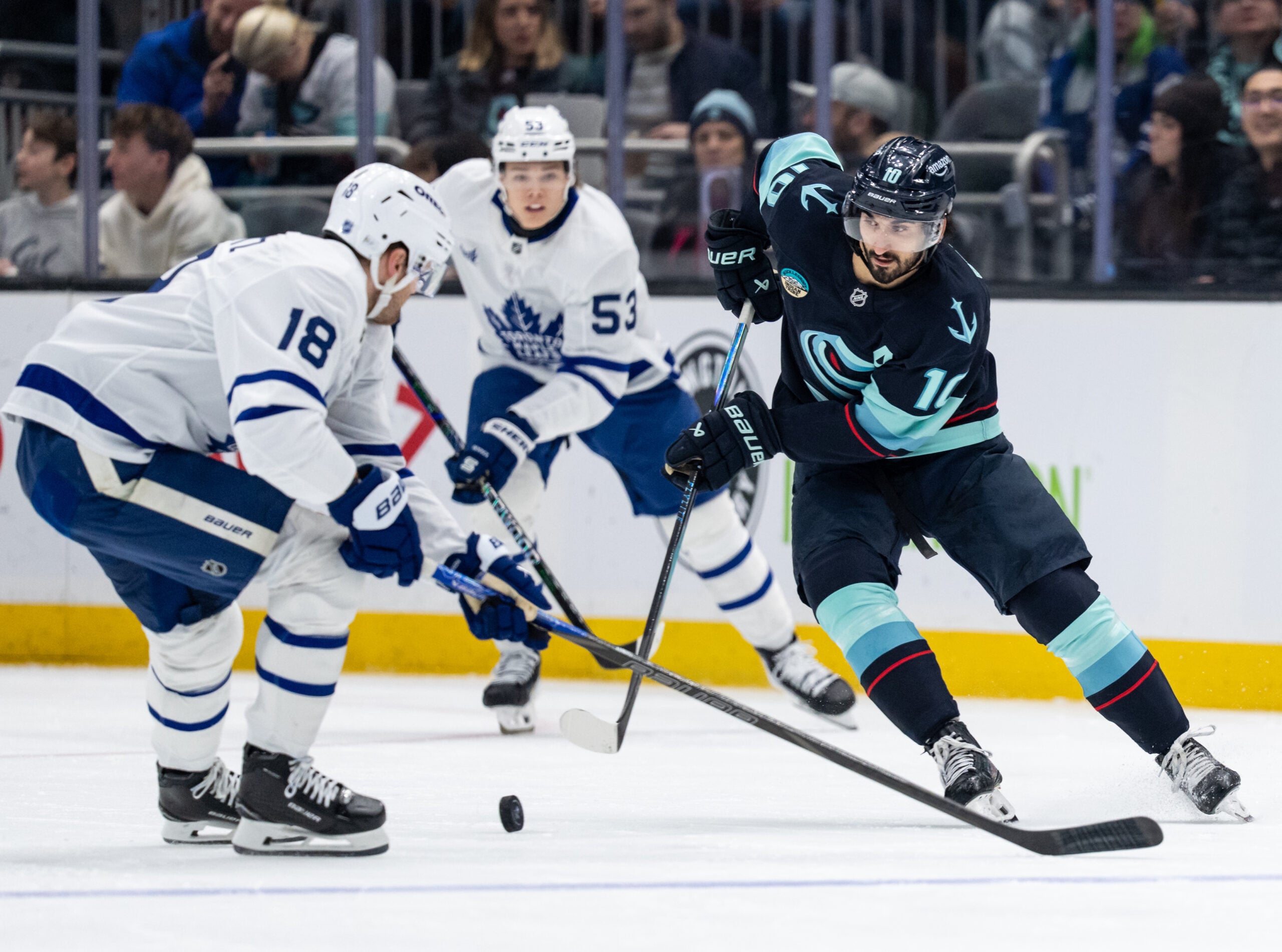 Jan 29, 2026; Seattle, Washington, USA; Seattle Kraken forward Matty Beniers (10) skates against defenseman Chris Tanev (8) during the second period at Climate Pledge Arena. Mandatory Credit: Stephen Brashear-Imagn Images