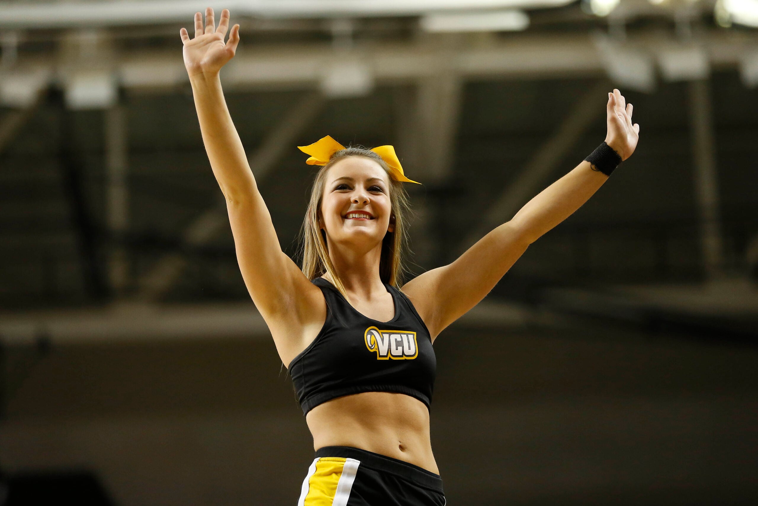 Mar 7, 2015; Richmond, VA, USA; A Virginia Commonwealth Rams cheerleader waves to the crowd during a stoppage in play against the George Mason Patriots in the first half at Stuart Siegel Center. The Rams won 71-60. Mandatory Credit: Geoff Burke-Imagn Images