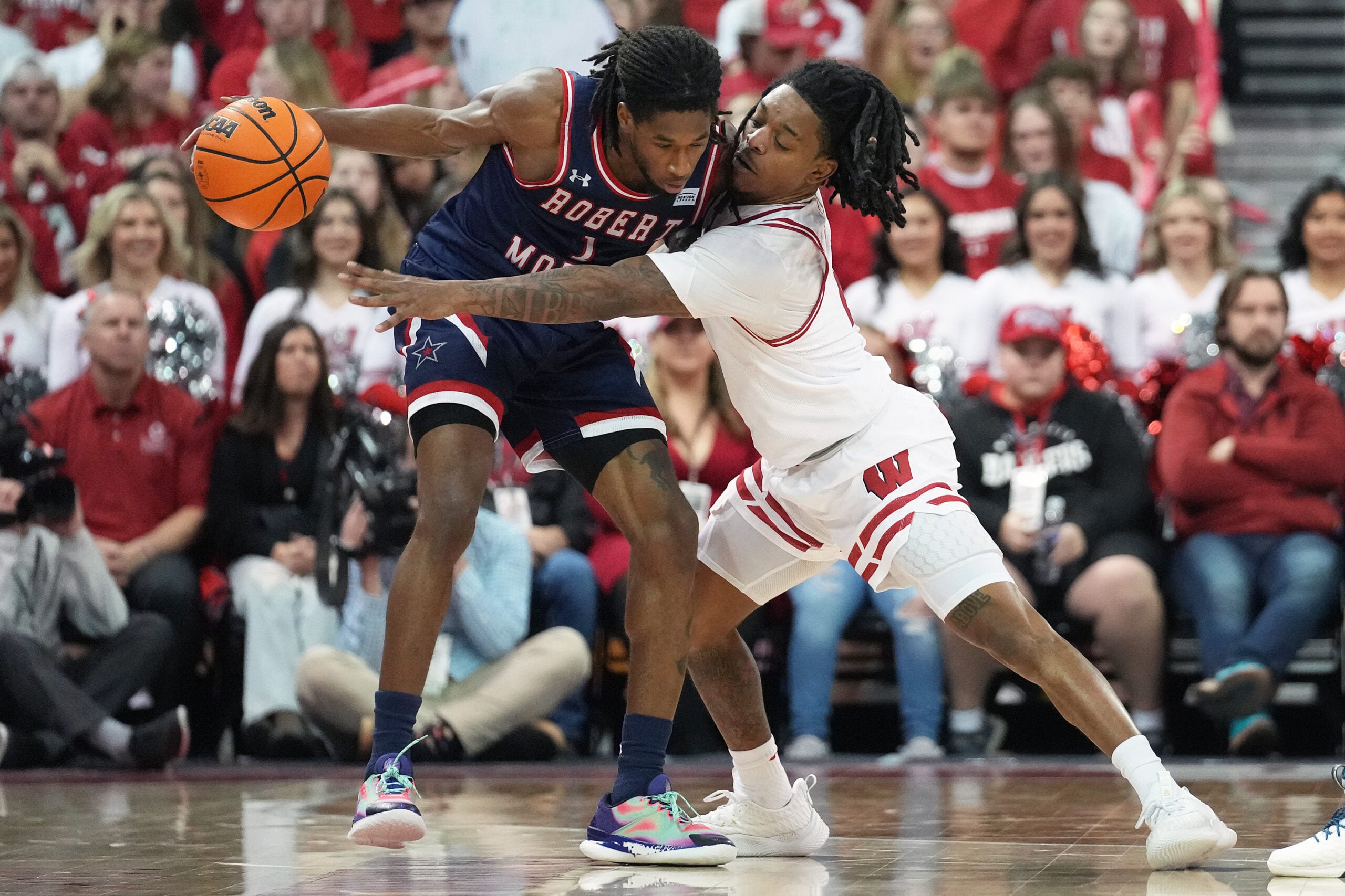 Nov 17, 2023; Madison, Wisconsin, USA; Wisconsin Badgers guard Kamari McGee (4) guards Robert Morris Colonials guard Justice Williams (1) during the second half at the Kohl Center. Mandatory Credit: Kayla Wolf-Imagn Images
