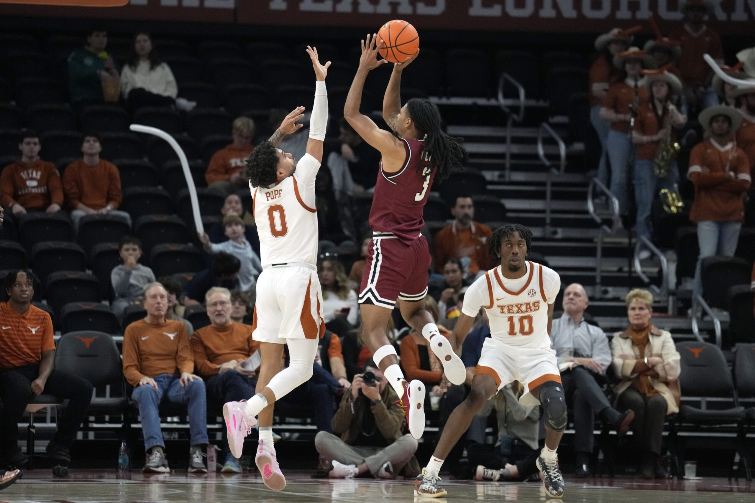 Dec 12, 2024; Austin, Texas, USA; New Mexico State Aggies guard Christian Cook (3) shoots over guard Jordan Pope (0) during the second half at Moody Center. Mandatory Credit: Scott Wachter-Imagn Images