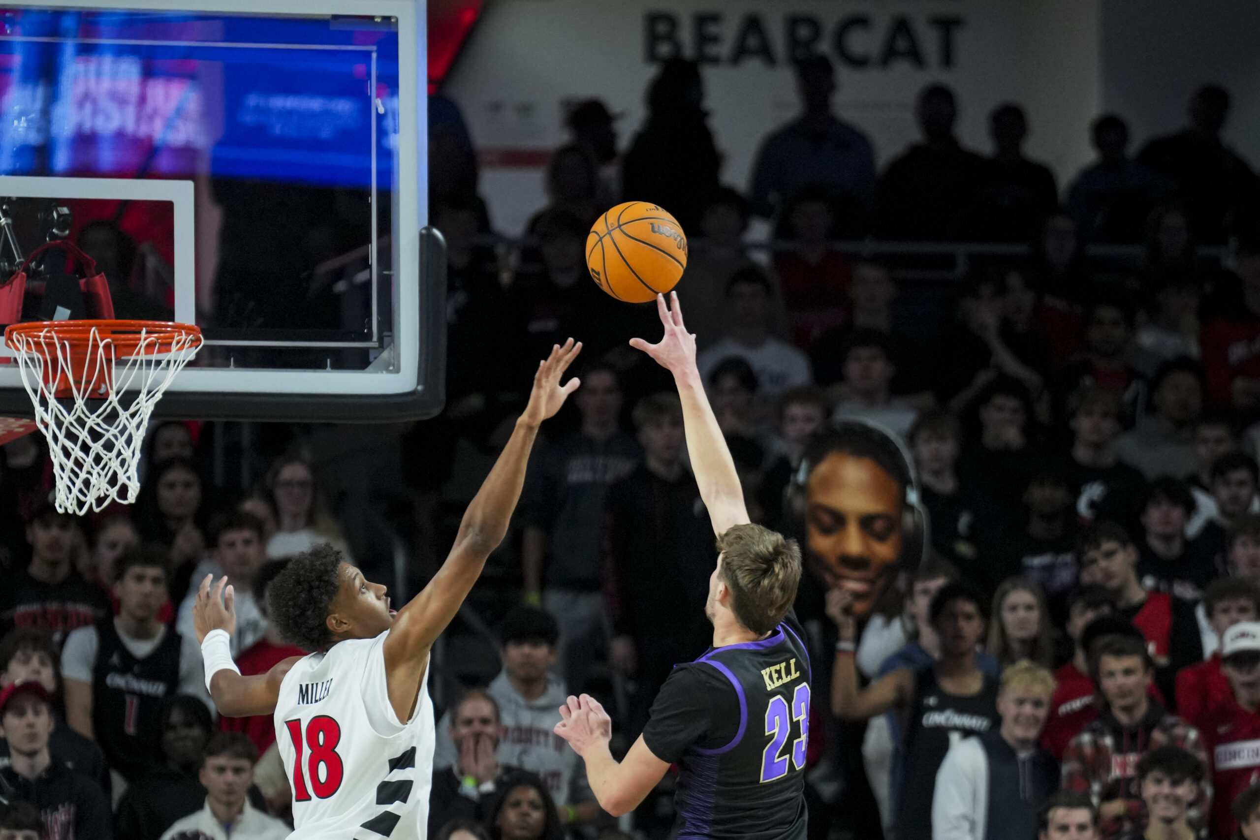 Nov 3, 2025; Cincinnati, Ohio, USA;  Western Carolina Catamounts forward Marcus Kell (23) shoots against Cincinnati Bearcats forward Baba Miller (18) in the first half at Fifth Third Arena. Mandatory Credit: Aaron Doster-Imagn Images