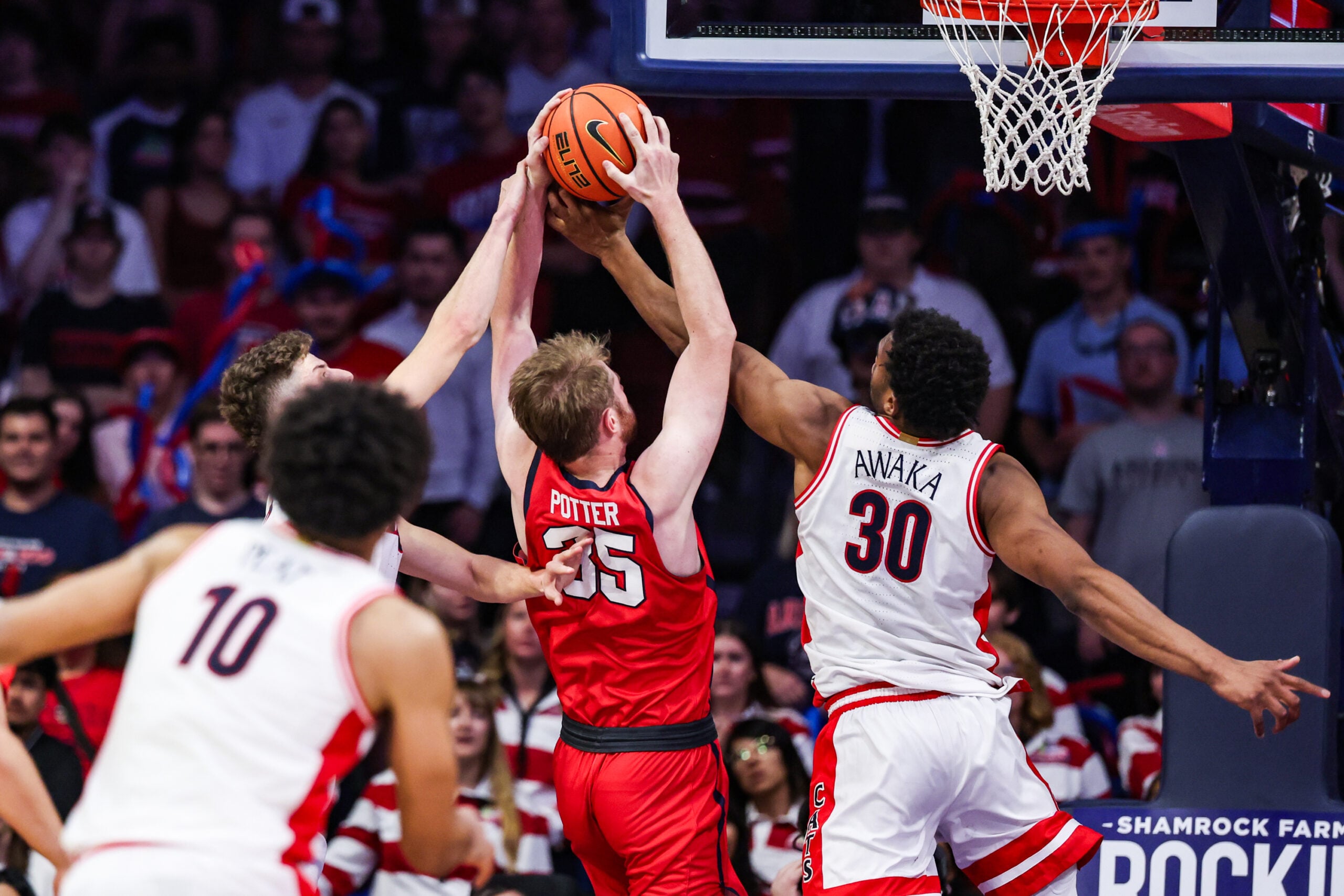 Nov 7, 2025; Tucson, Arizona, USA; Utah Tech Trailblazers forward Ethan Potter (35) and Arizona Wildcats forward Tobe Awaka (30) both reach for the rebound during the second half of the game at McKale Memorial Center. Mandatory Credit: Aryanna Frank-Imagn Images