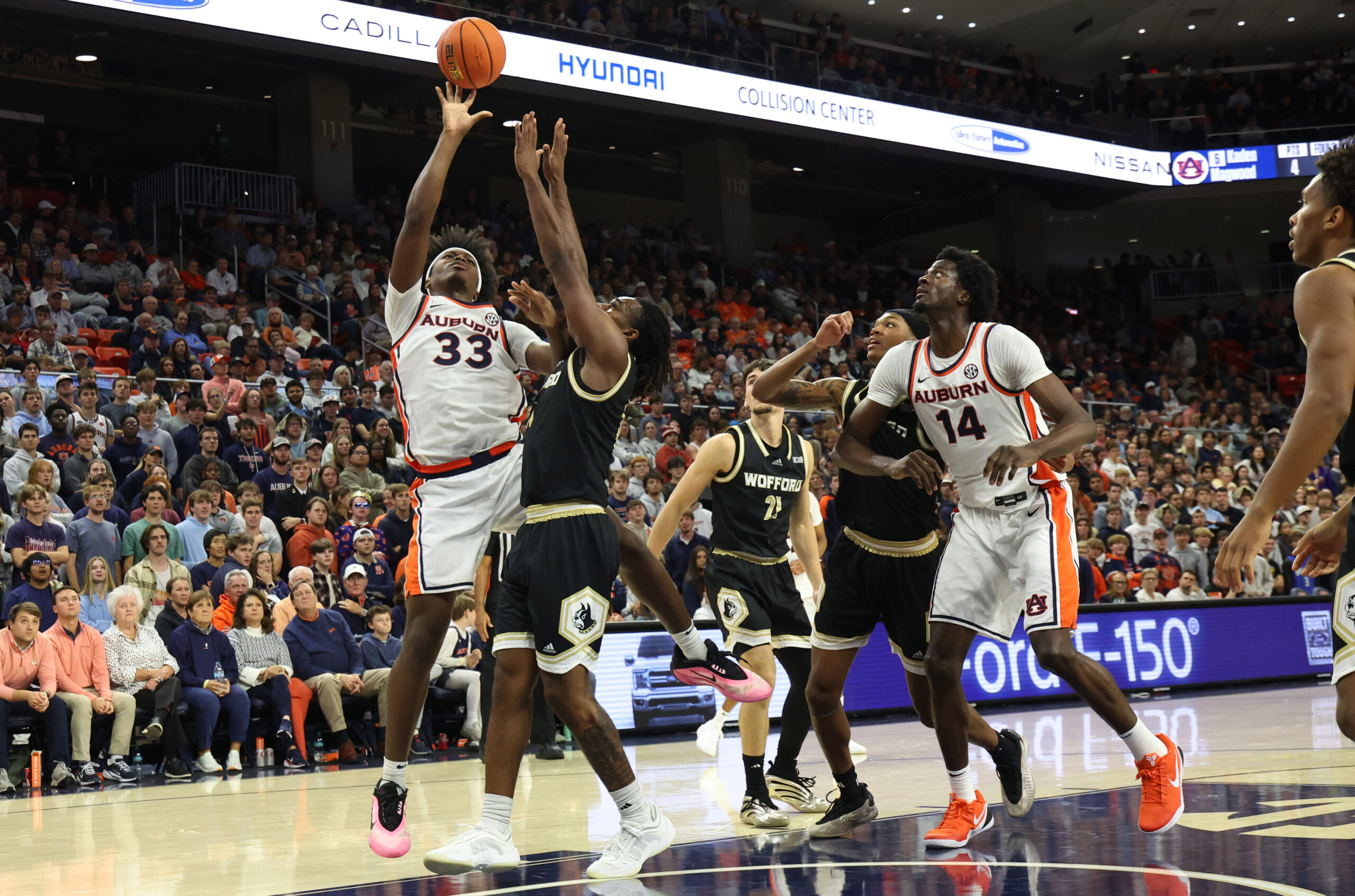 Nov 11, 2025; Auburn, Alabama, USA; Wofford Terriers guard Kahmare Holmes (11) tries to block the shot of Auburn Tigers forward Sebastian Williams-Adams (33) during the second half at Neville Arena. Mandatory Credit: John Reed-Imagn Images