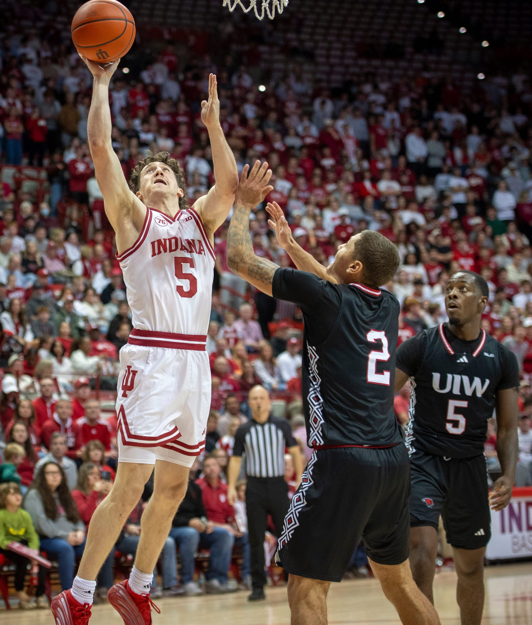 Indiana's Conor Enright (5) shoots over Incarnate Word's Tahj Staveskie (2) and Davion Bailey (5) during the Indiana versus Incarnate Word men's basketball game at Simon Skjodt Assembly Hall on Sunday, Nov. 16, 2025.