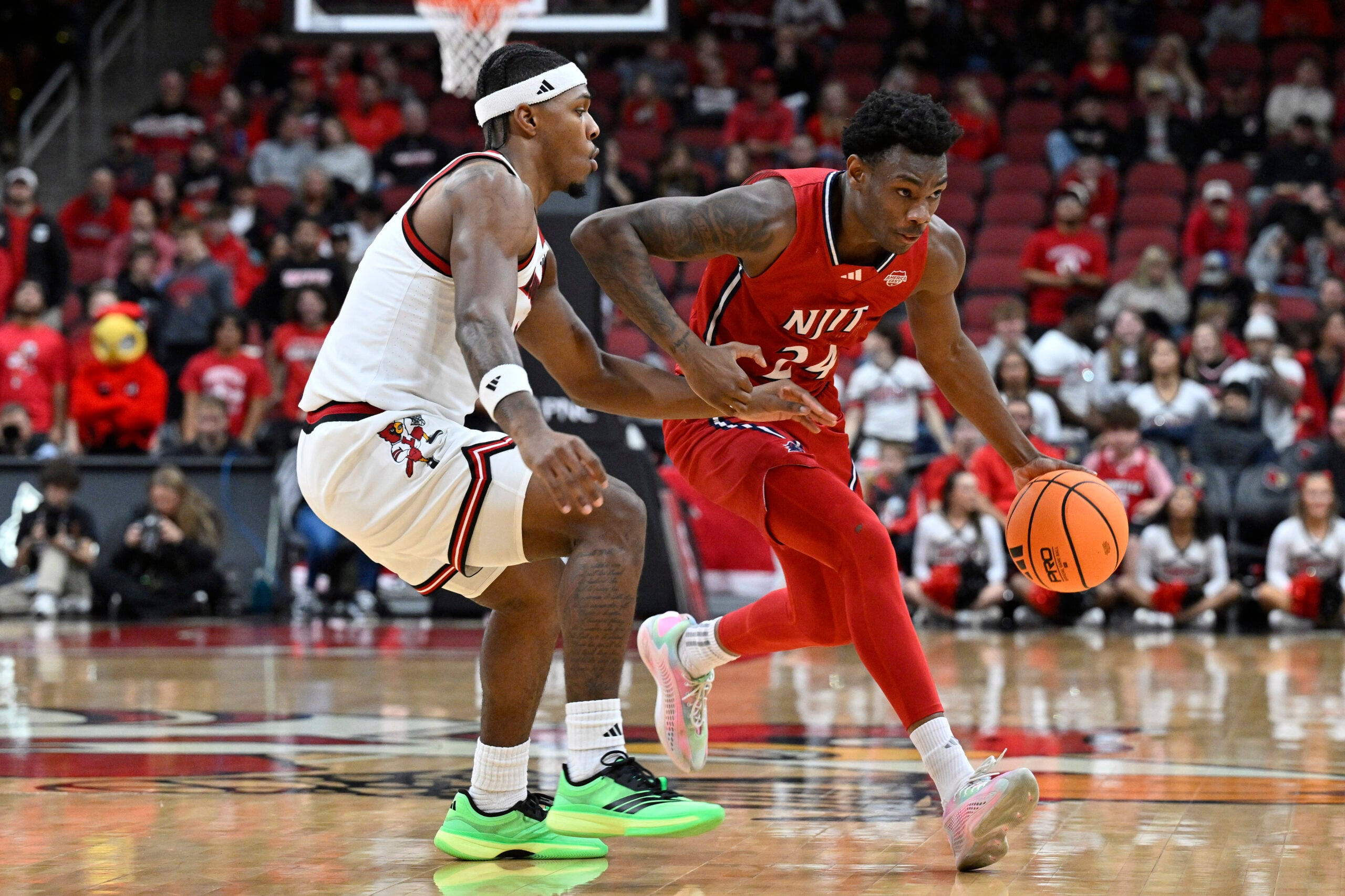 Nov 26, 2025; Louisville, Kentucky, USA; NJIT Highlanders guard Ari Fulton (24) dribbles against Louisville Cardinals guard Ryan Conwell (3) during the first half at KFC Yum! Center. Mandatory Credit: Jamie Rhodes-Imagn Images