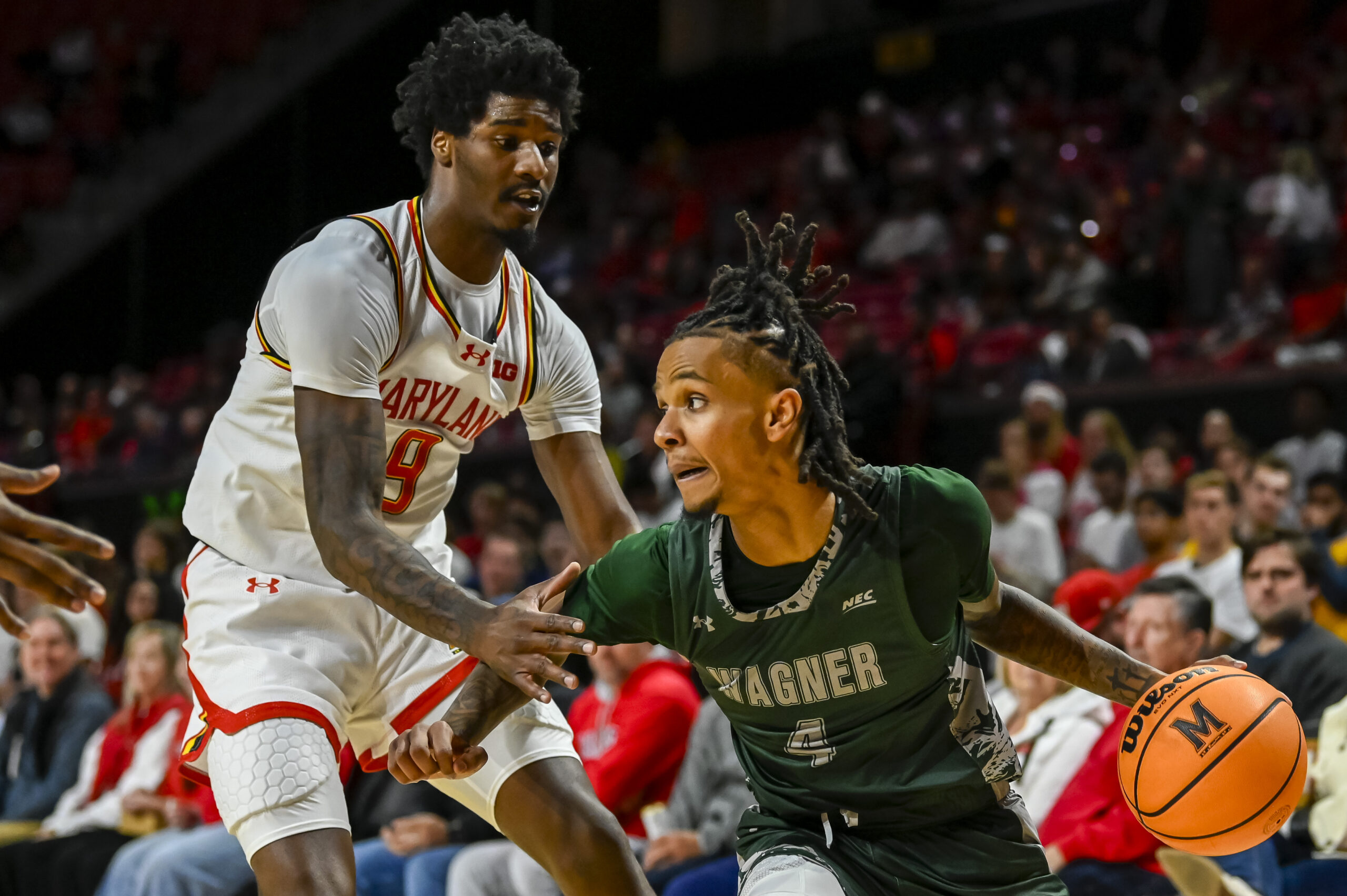 Dec 2, 2025; College Park, Maryland, USA;  Wagner Seahawks guard John Awoke (4) makes a move to the basket on Maryland Terrapins forward Solomon Washington (9) during the first half at Xfinity Center. Mandatory Credit: Tommy Gilligan-Imagn Images