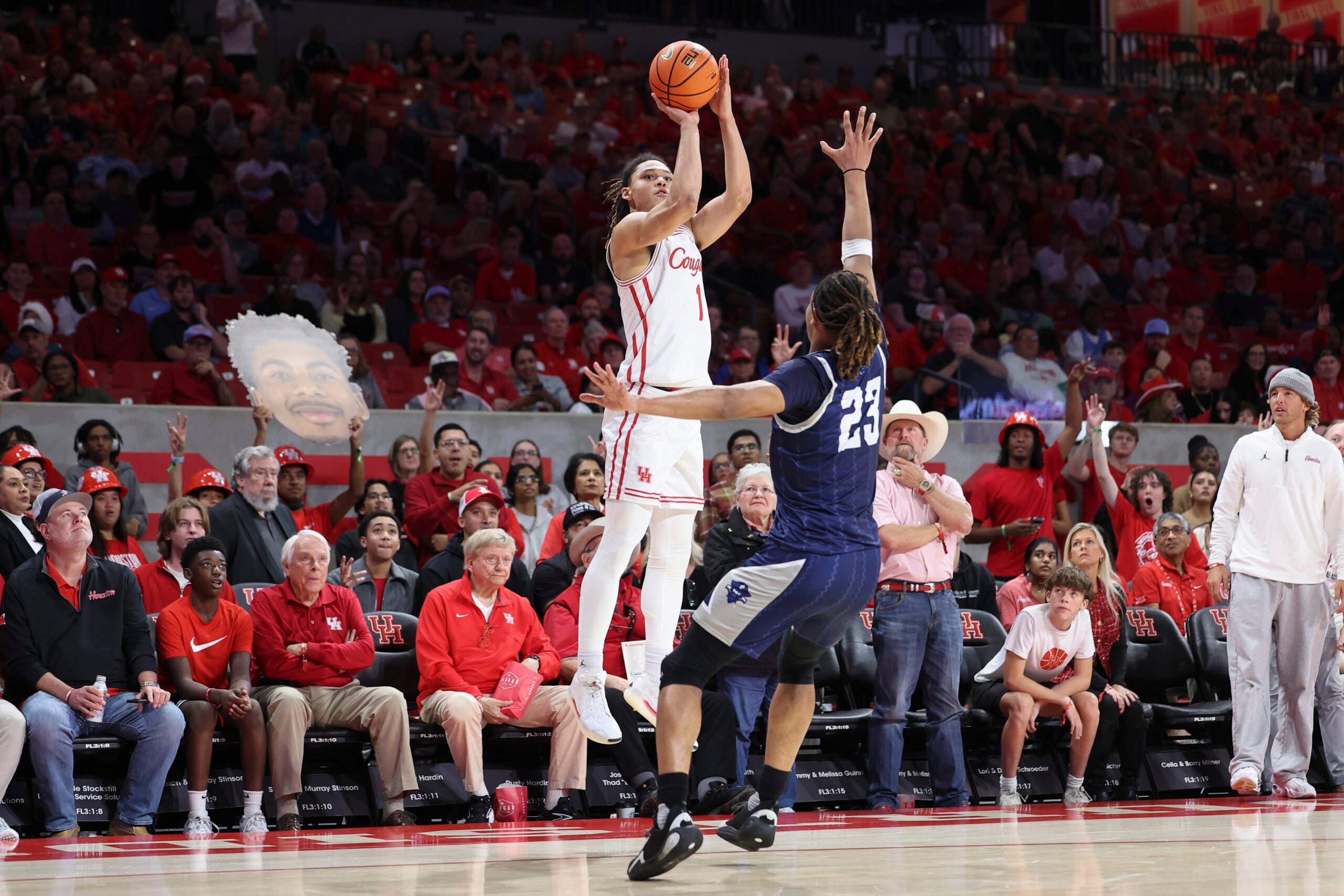 Dec 13, 2025; Houston, Texas, USA; Houston Cougars guard Isiah Harwell (1) shoots the ball as New Orleans Privateers forward MJ Thomas (23) defends during the first half at Fertitta Center. Mandatory Credit: Troy Taormina-Imagn Images