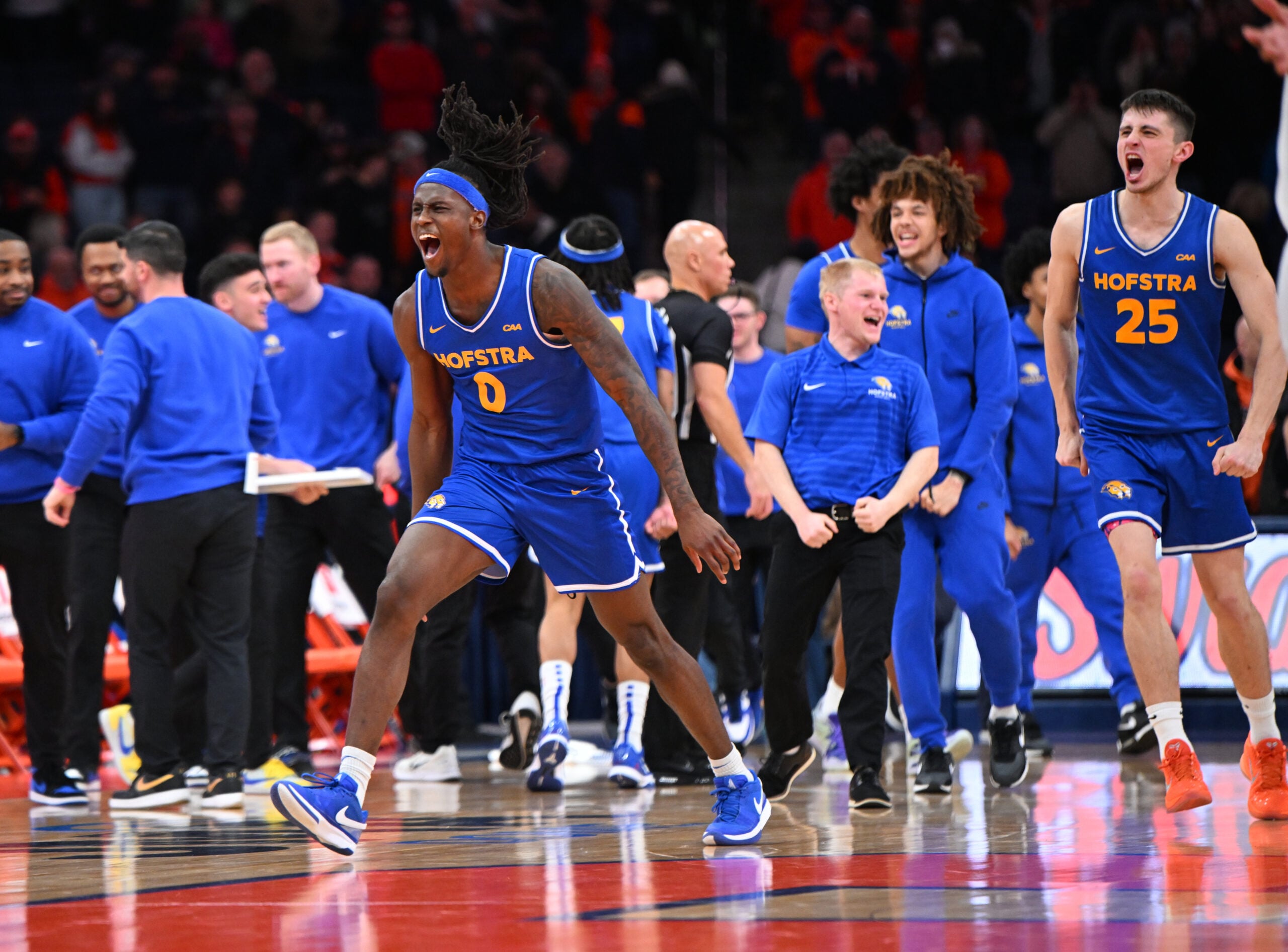 Dec 13, 2025; Syracuse, New York, USA; Hofstra Pride guard Biggie Patterson (0) and the bench react to winning a game against the Syracuse Orange at the JMA Wireless Dome. Mandatory Credit: Mark Konezny-Imagn Images