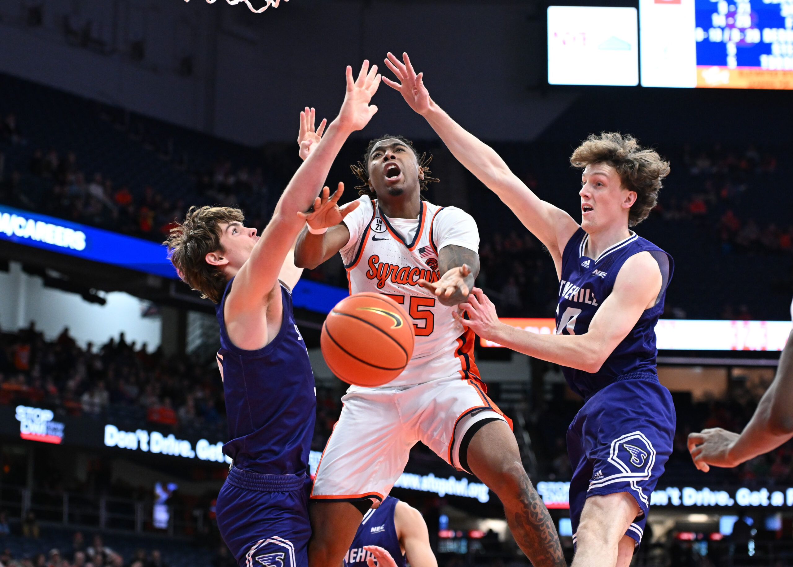 Dec 22, 2025; Syracuse, New York, USA; Syracuse Orange Guard Bryce Zephir (55) is fouled on a play with Stonehill Skyhawks forward Cory Lovell (left) and forward Pearse McGuinn (31) in the second half at the JMA Wireless Dome. Mandatory Credit: Mark Konezny-Imagn Images