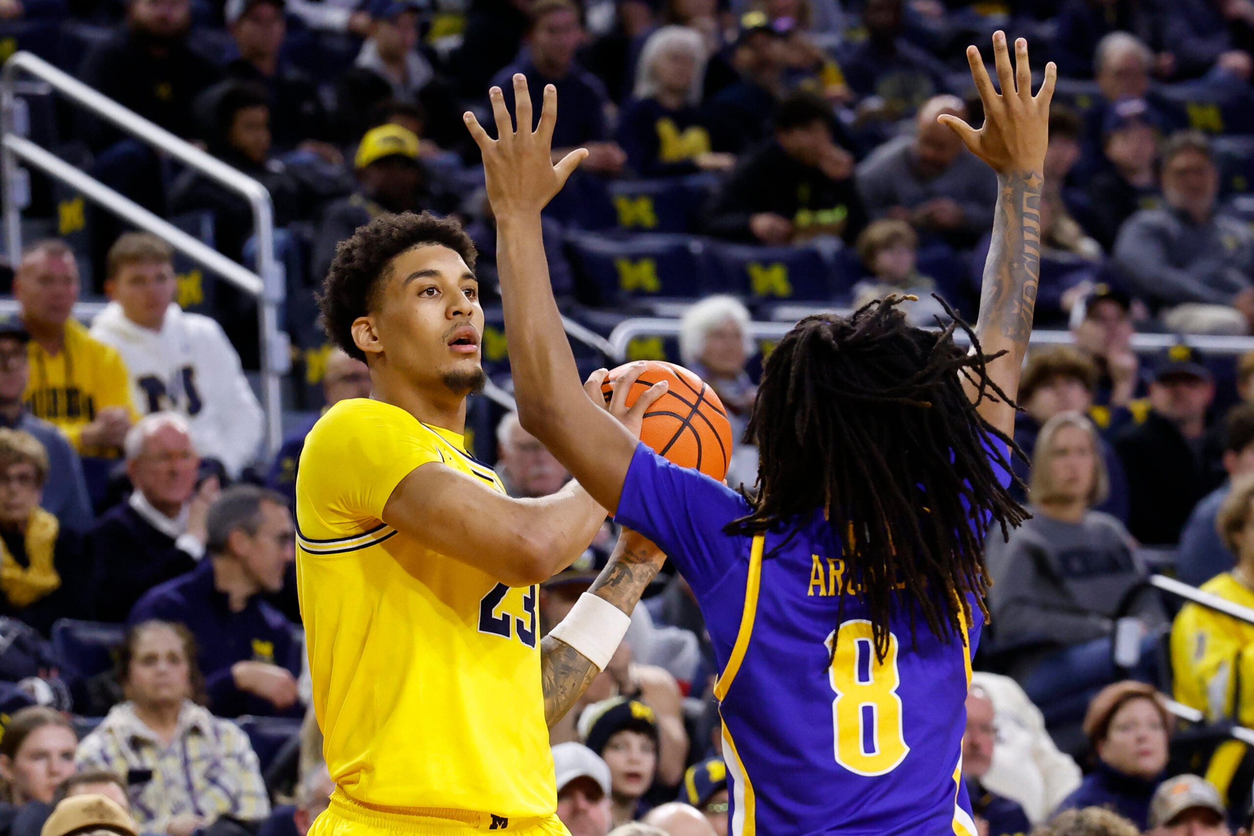 Dec 29, 2025; Ann Arbor, Michigan, USA;  Michigan Wolverines forward Yaxel Lendeborg (23) is defended by McNeese Cowboys guard Tyshawn Archie (8) in the first half at Crisler Center. Mandatory Credit: Rick Osentoski-Imagn Images