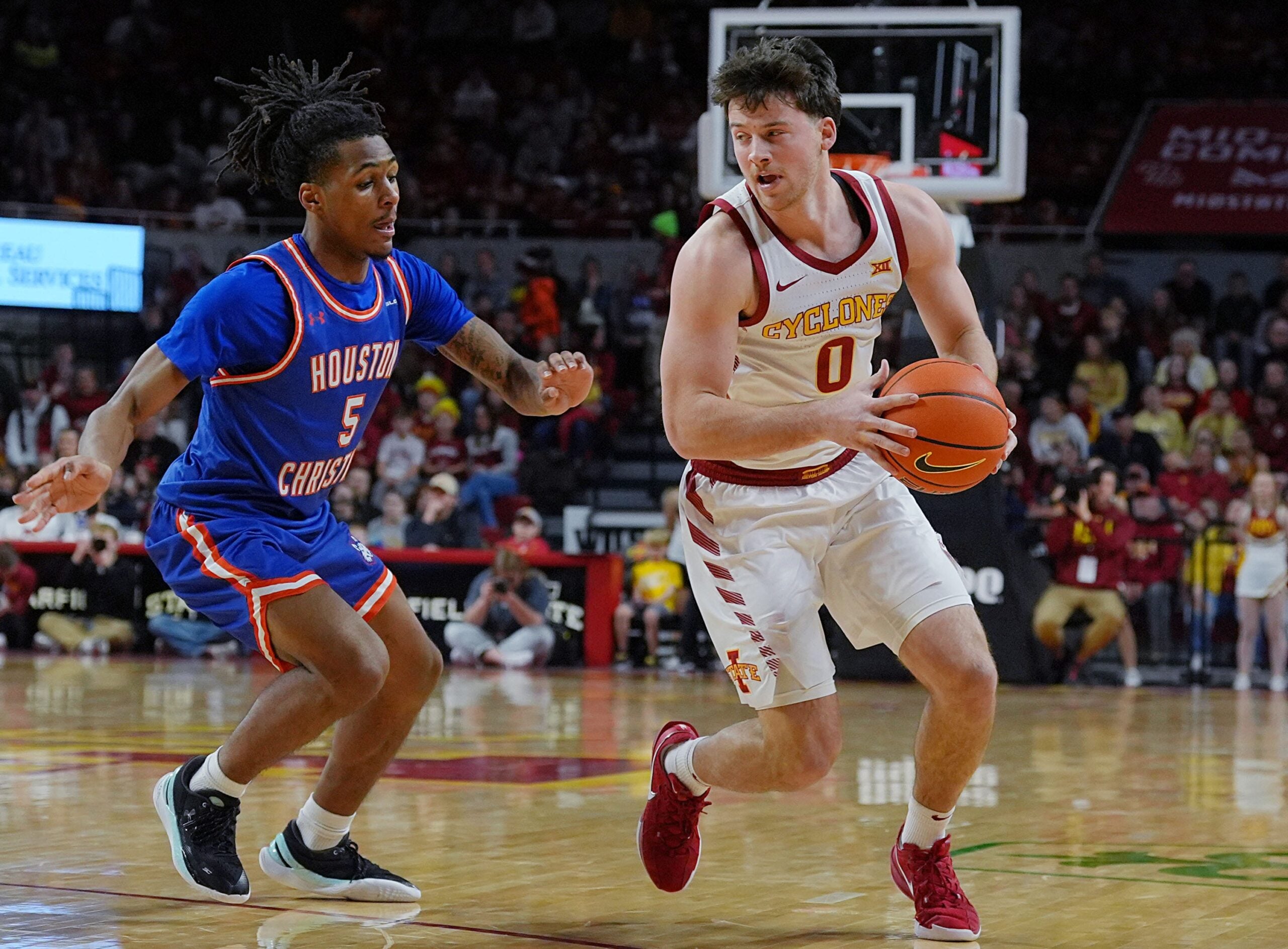 Iowa State Cyclones guard Nate Heise (0) drives with the ball around Houston Christian Huskies guard D'Aundre Samuels (5) during the first half in the NCAA men’s basketball on Dec. 29. 2025, at Hilton Coliseum in Ames, Iowa.