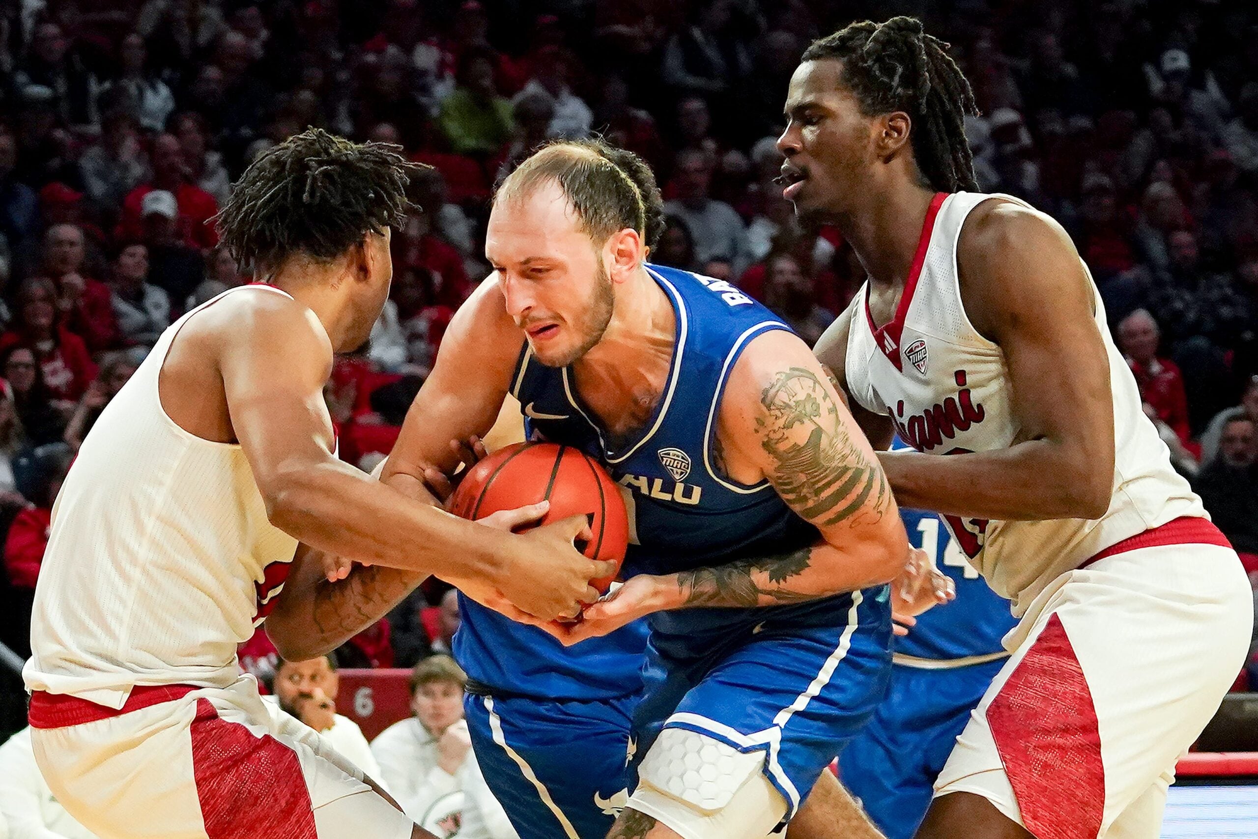 Miami (OH) RedHawks and Buffalo Bulls players battle for possession of the ball in the second half of a NCAA men’s basketball game between the Miami RedHawks and Buffalo Bulls, Saturday, Jan. 17, 2026, at Millett Hall in Oxford, Oh. RedHawks won 105-102.