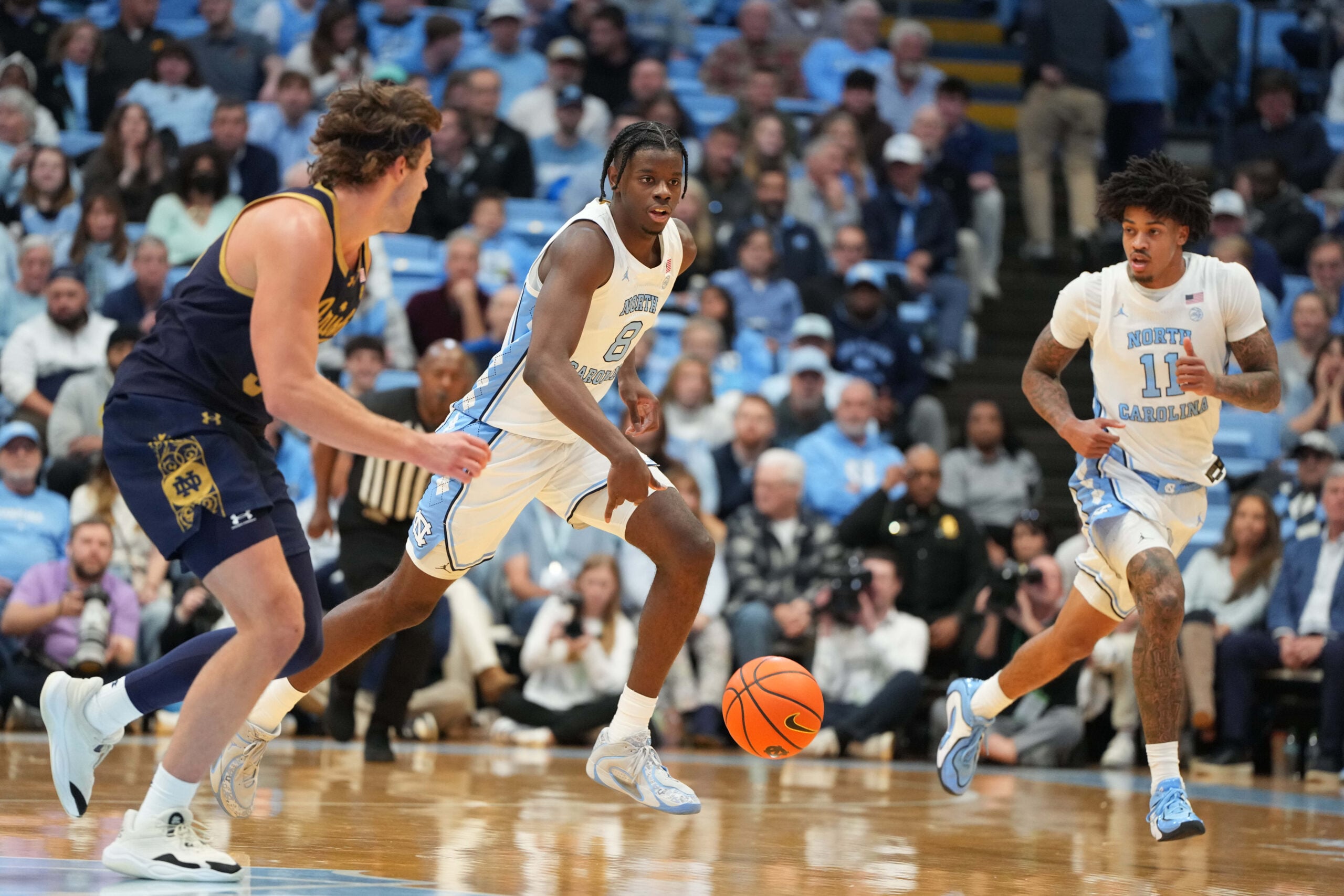 Jan 21, 2026; Chapel Hill, North Carolina, USA; North Carolina Tar Heels forward Caleb Wilson (8) brings the ball up the court as Notre Dame Fighting Irish forward Ryder Frost (7) defends in the second half at Dean E. Smith Center. Mandatory Credit: Bob Donnan-Imagn Images