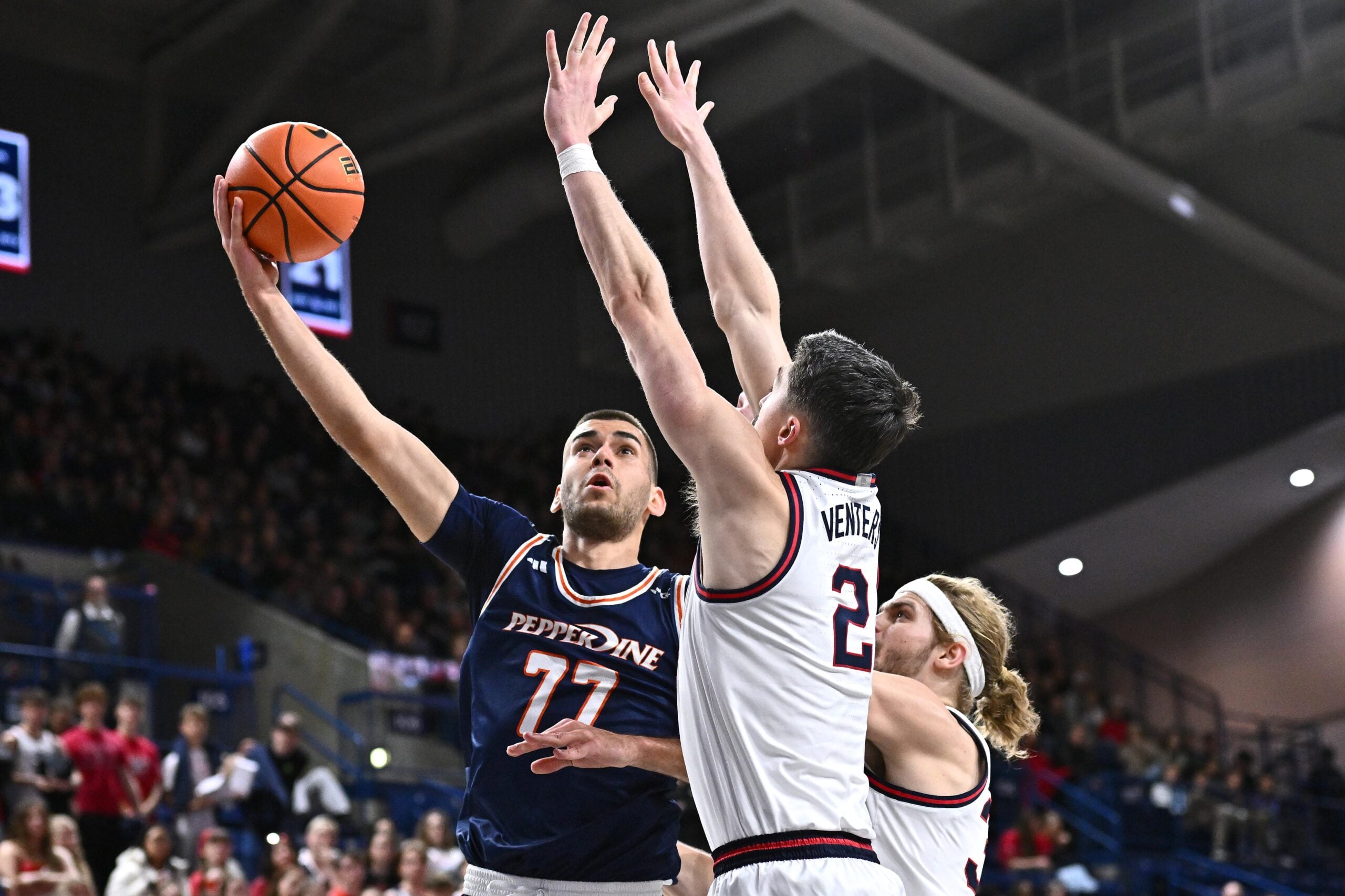Jan 21, 2026; Spokane, Washington, USA; Pepperdine Waves guard Luka Vudragovic (77) shoots the ball against Gonzaga Bulldogs forward Steele Venters (2) in the second half at McCarthey Athletic Center. Mandatory Credit: James Snook-Imagn Images