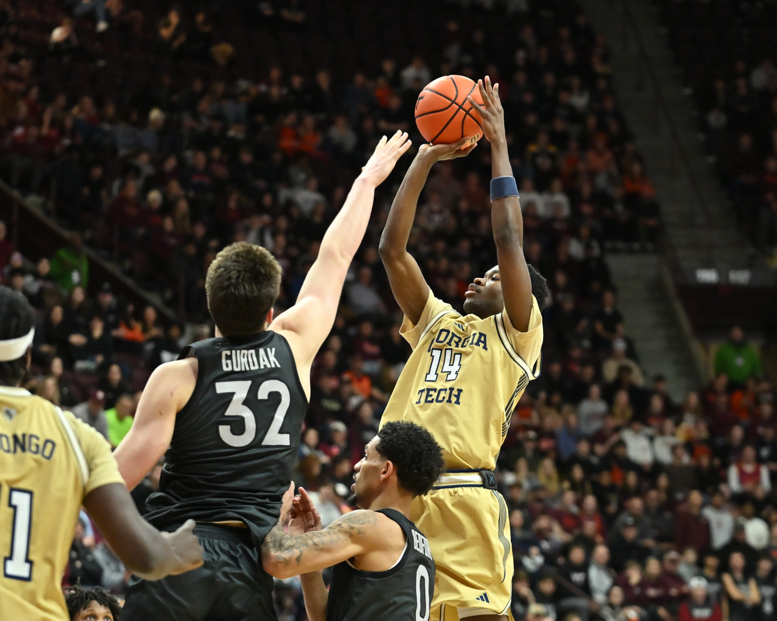 Jan 27, 2026; Blacksburg, Virginia, USA;  Georgia Tech Yellow Jackets forward Kowacie Reeves Jr. (14) shoots a shot as Virginia Tech Hokies center Christian Gurdak (32) defends during the first half at Cassell Coliseum. Mandatory Credit: Brian Bishop-Imagn Images