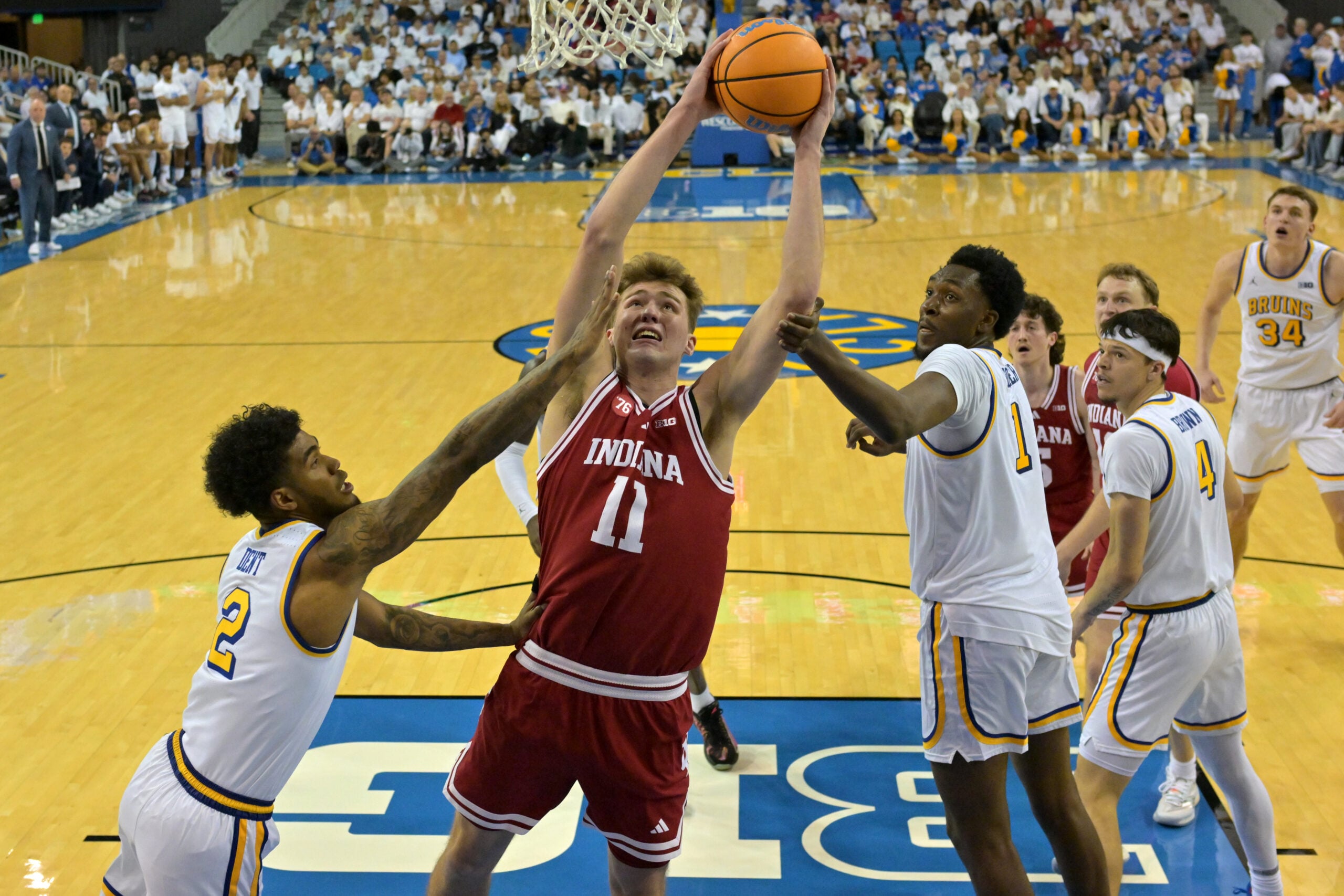 Jan 31, 2026; Los Angeles, California, USA;  Indiana Hoosiers forward Trent Sisley (11) is defended by UCLA Bruins guard Donovan Dent (2) and forward Xavier Booker (1) in the second half at Pauley Pavilion presented by Wescom Financial. Mandatory Credit: Jayne Kamin-Oncea-Imagn Images