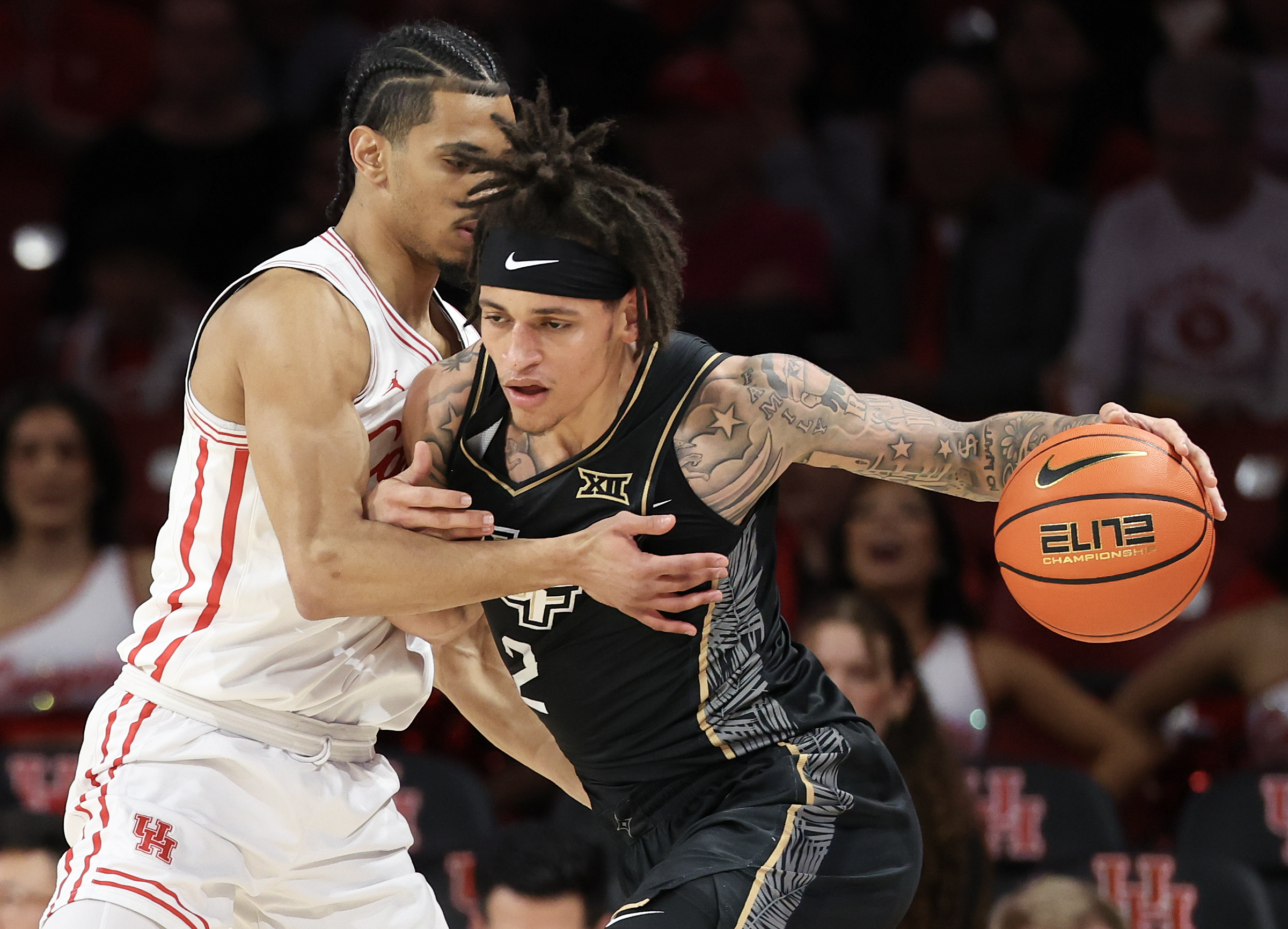 Feb 4, 2026; Houston, Texas, USA; UCF Knights guard Riley Kugel (2) drives against Houston Cougars guard Milos Uzan (7) in the first half at Fertitta Center. Mandatory Credit: Thomas Shea-Imagn Images