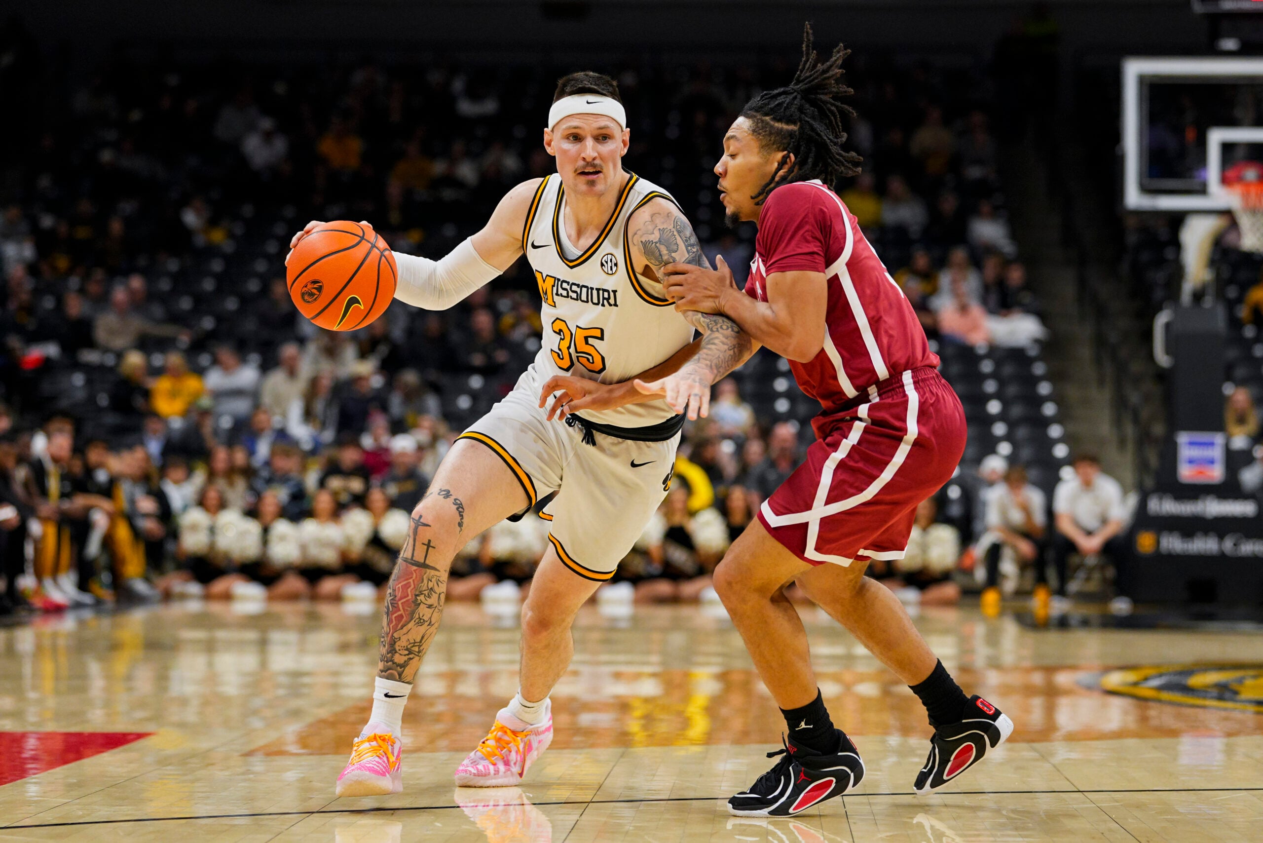 Jan 24, 2026; Columbia, Missouri, USA; Missouri Tigers guard Jacob Crews (35) drives against Oklahoma Sooners guard Nijel Pack (9) during the first half at Mizzou Arena. Mandatory Credit: Jay Biggerstaff-Imagn Images